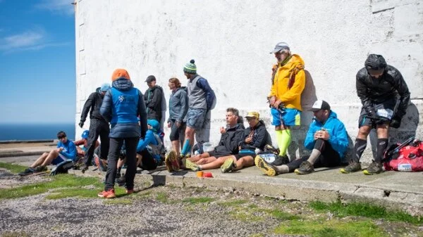 A welcome sit down at the finish line at Cape Wrath Lighthouse. Credit: Jimmy Hyland/JHPvisuals.co.uk