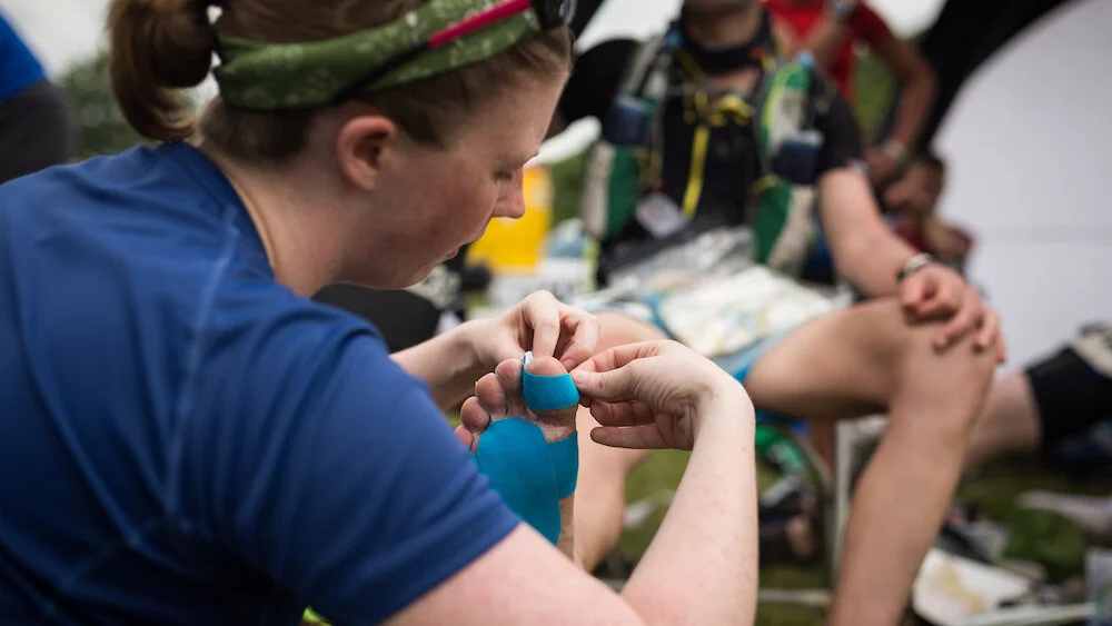 Medic helping with blister treatment, your own blister kit is mandatory! ©Guillem Casanova​