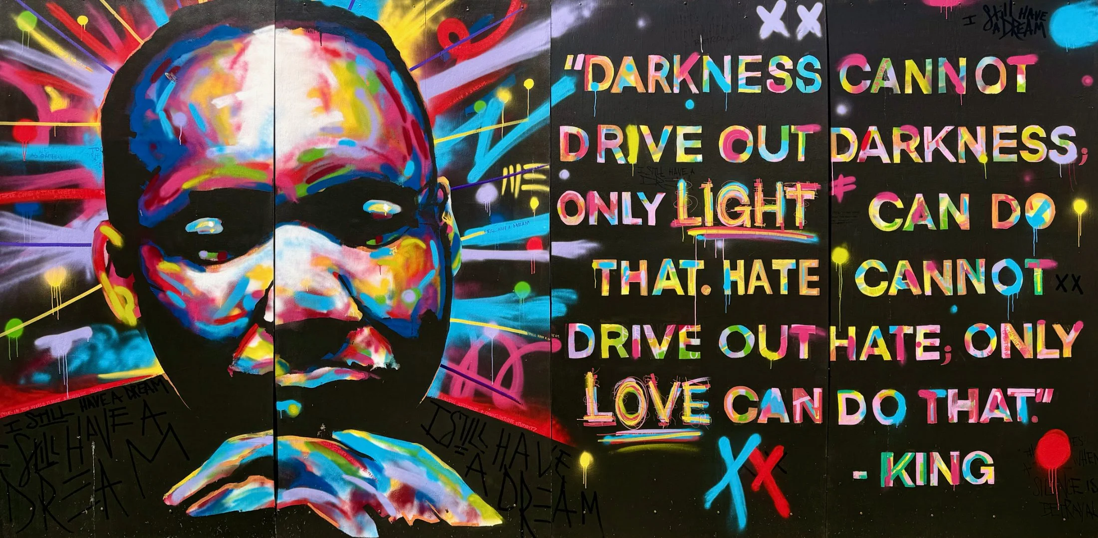 Colorful mural painting of Martin Luther King Junior's face with quote, "Darkness cannot drive out darkness, only light can do that. Hate cannot drive out hate, only LOVE can do that."