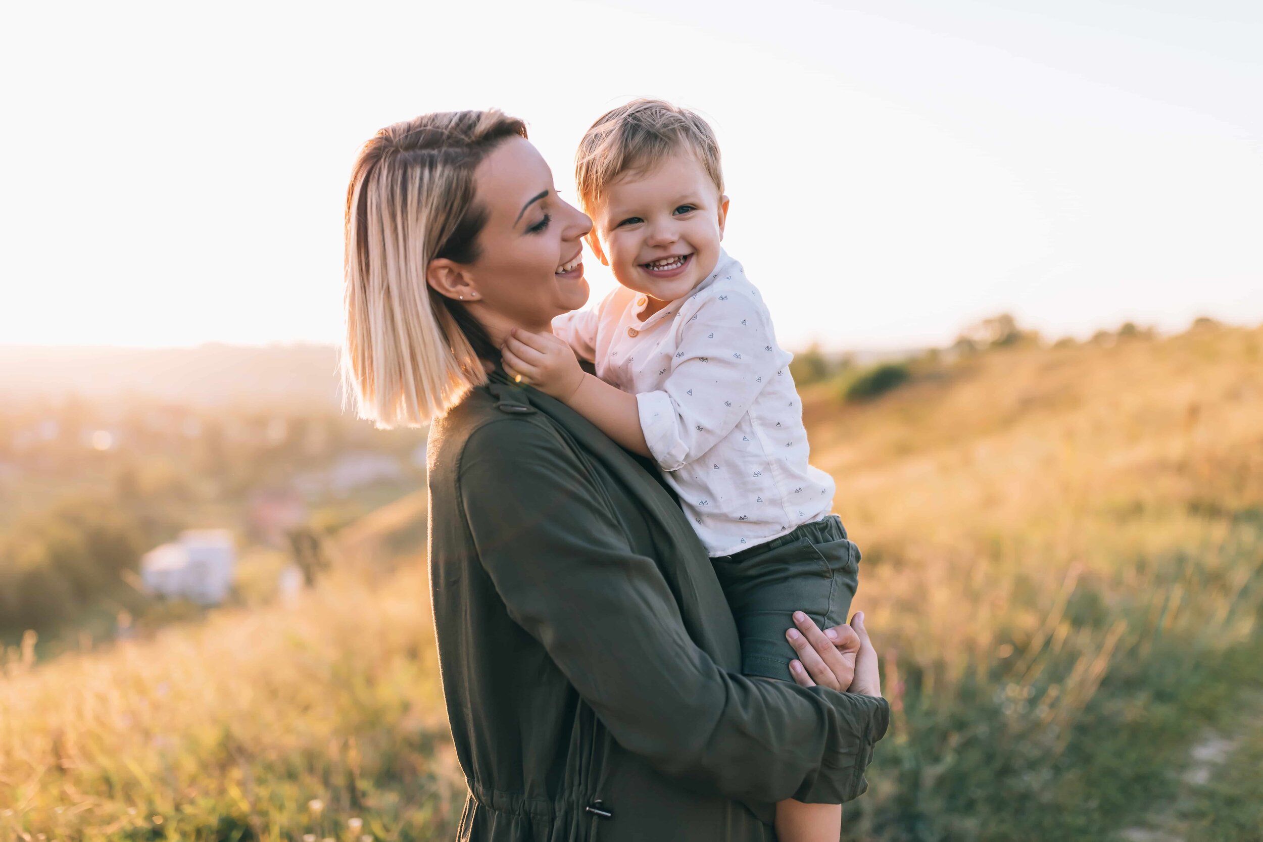 Сын е молодую маму. Сын носит маму на руках. Мама с ребеночком. Мальчик обнимает маму. Мама обнимает сына.