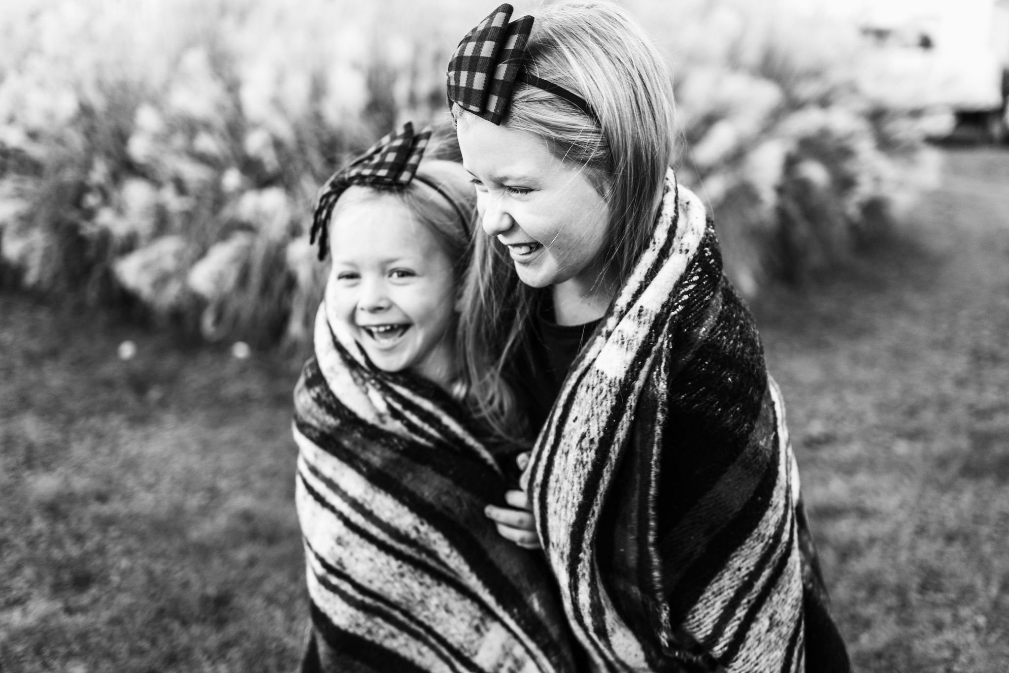 Sisters bundled in a blanket for holiday family photo
