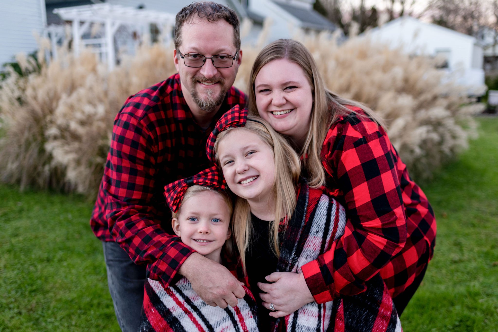 Mom, Dad and daughters together in holiday family photo outside