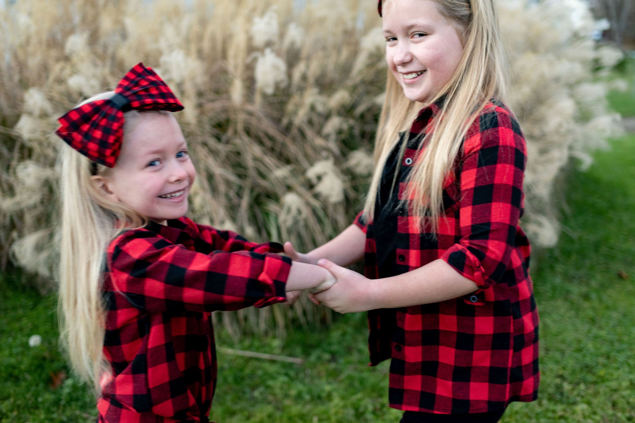 Sisters spinning together during family christmas holiday photos