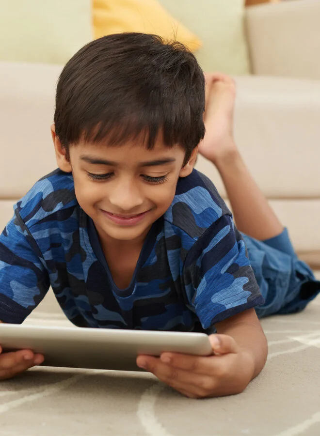 Child participating in an online speech therapy session through teletherapy from home.