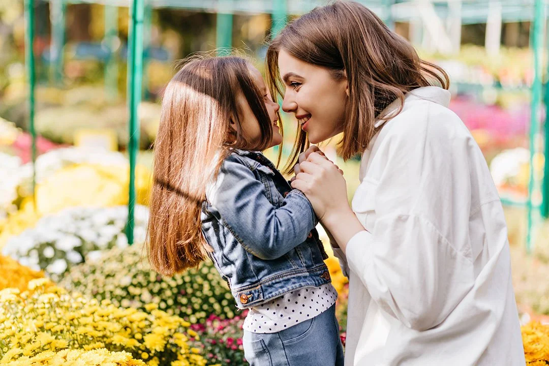 Parent and young child smiling together outdoors, representing family support during the speech therapy evaluation and treatment planning process.