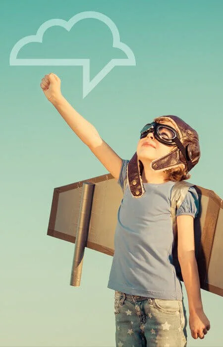 Child wearing paper airplane wings and looking upward, symbolizing hope and confidence in a child’s communication journey.