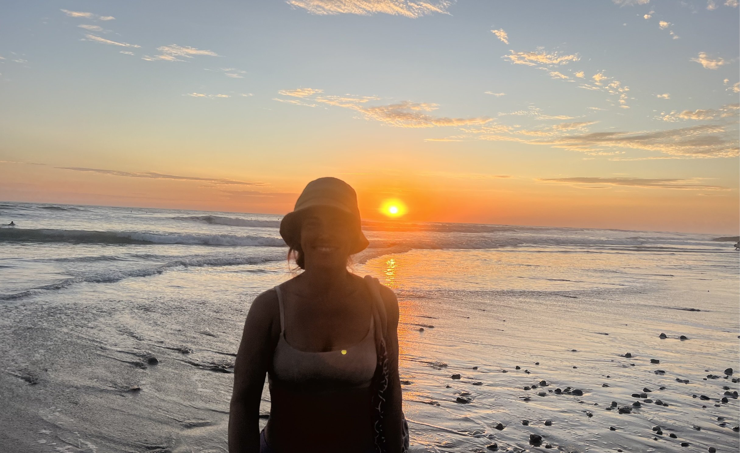 Silhouette of Christina Burnham at the beach at sunset, representing the personal values and balance behind her online speech therapy practice.