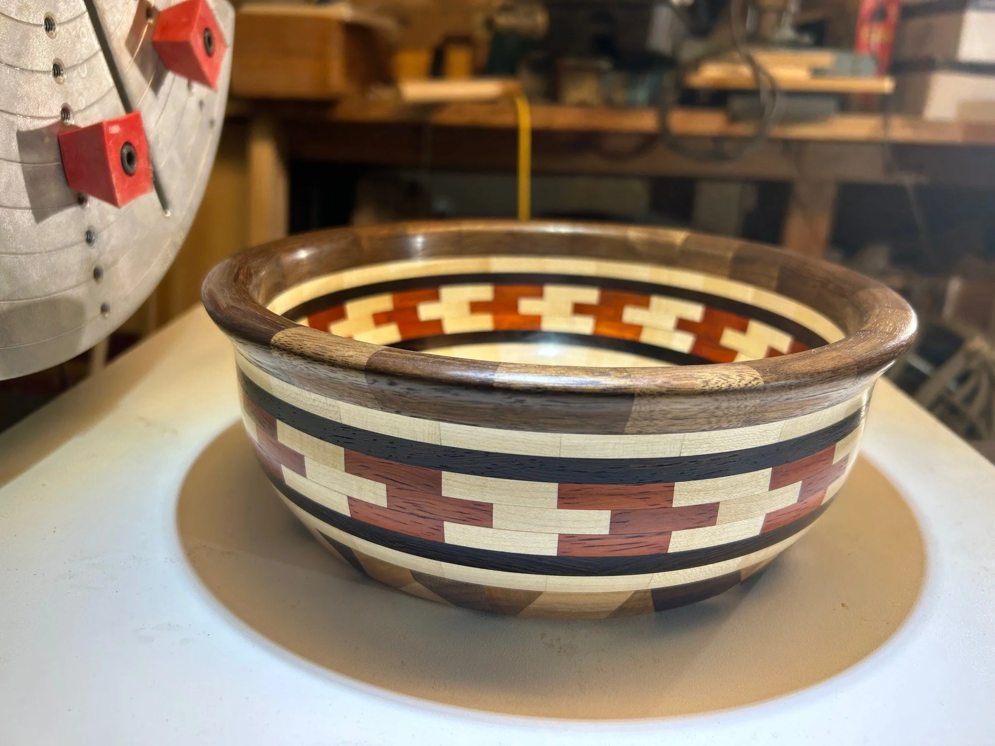 Custom wood turned bowl sitting next to lathe in woodshop