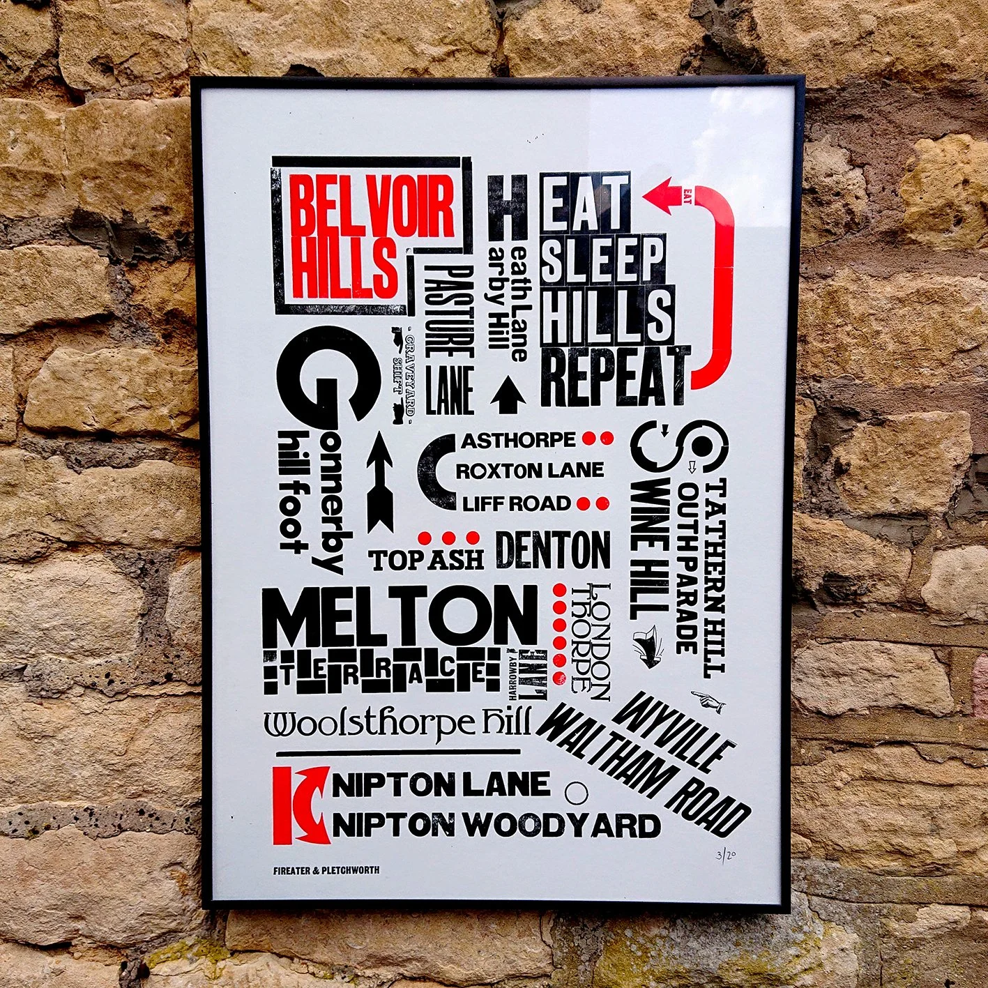 Decorative wall art displaying a stylized map of the Belvoir Hills area with street names and directions, including routes like Hatch Lane, Earth Lane, and Nipton Lane, against a stone wall background.
