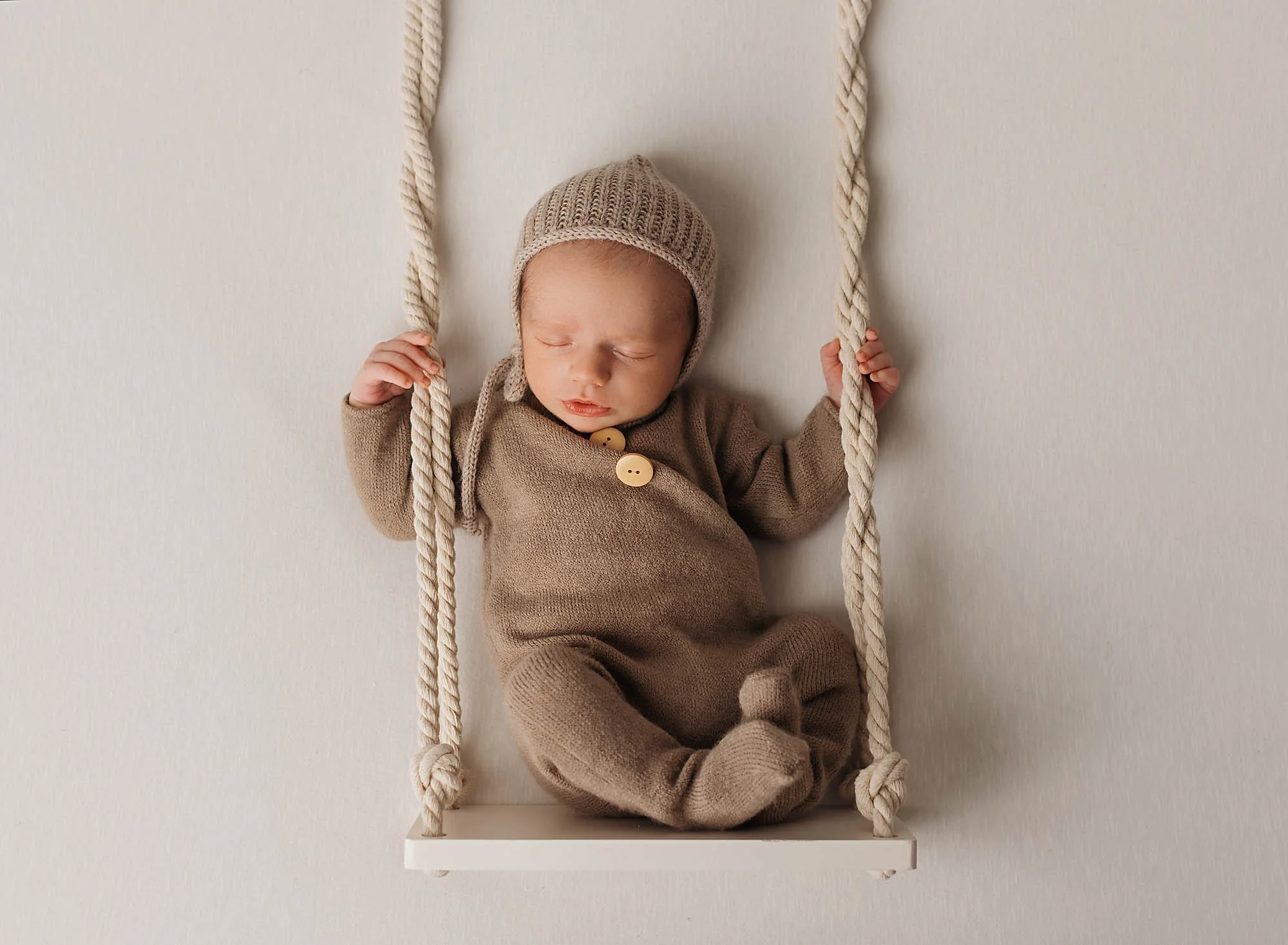 cute newborn baby b oy in a swing