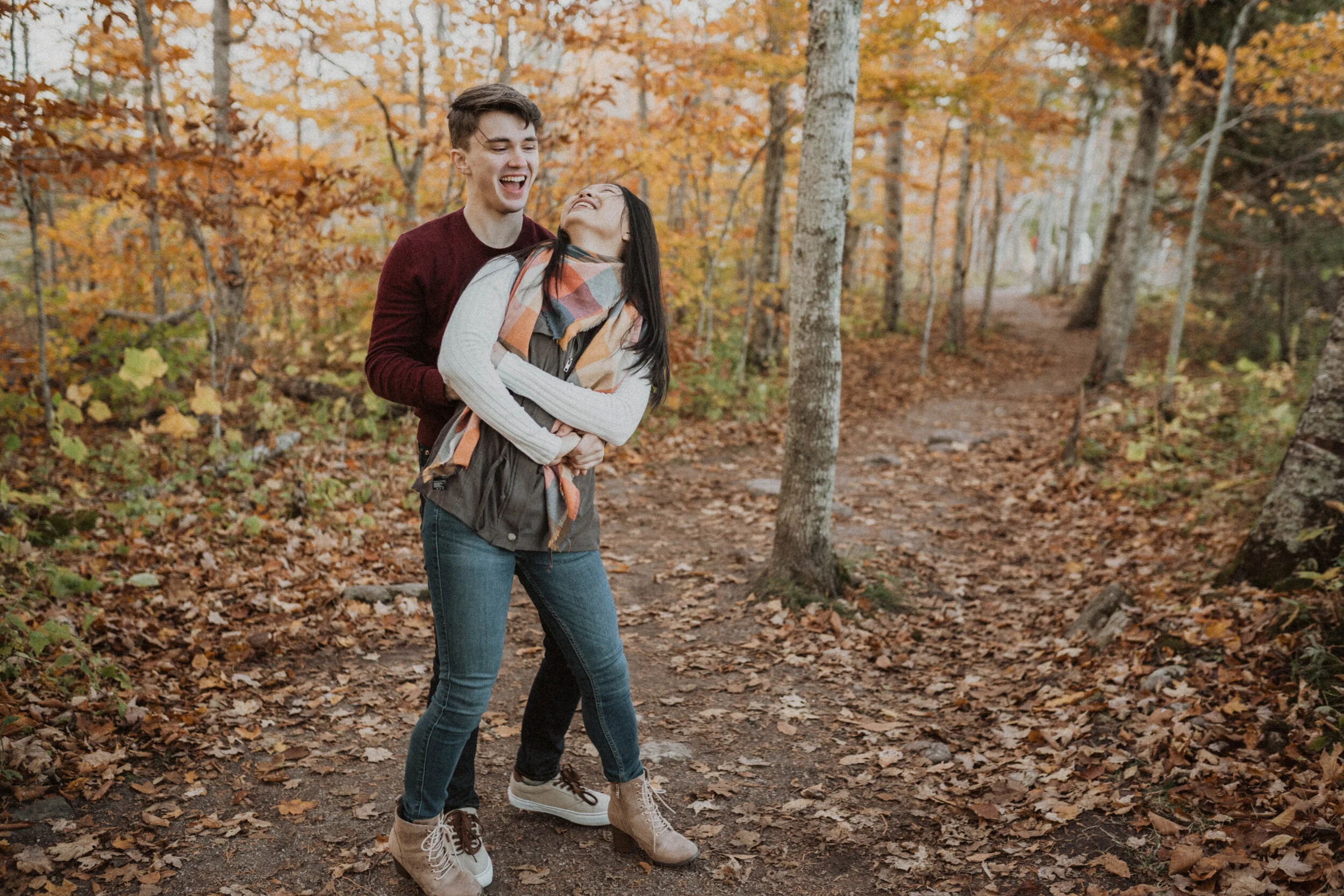 couple laughing in the fall colors outside of asheville