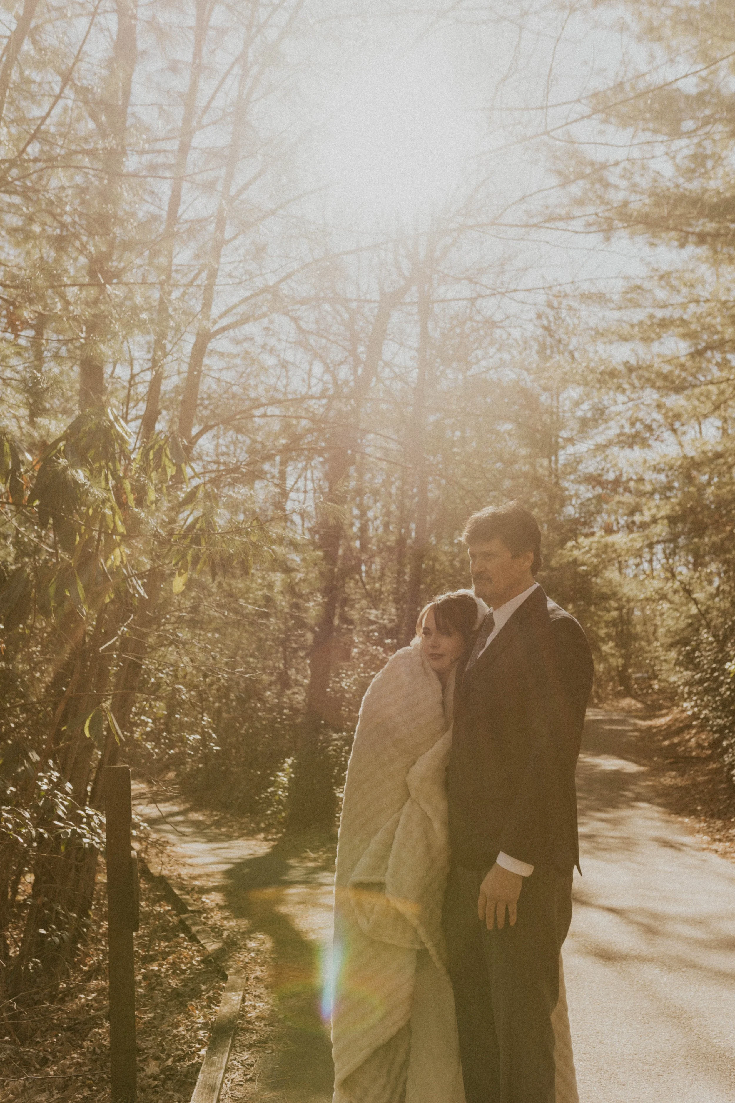 Bride wrapped in blanket during cold windy Asheville mountain elopement