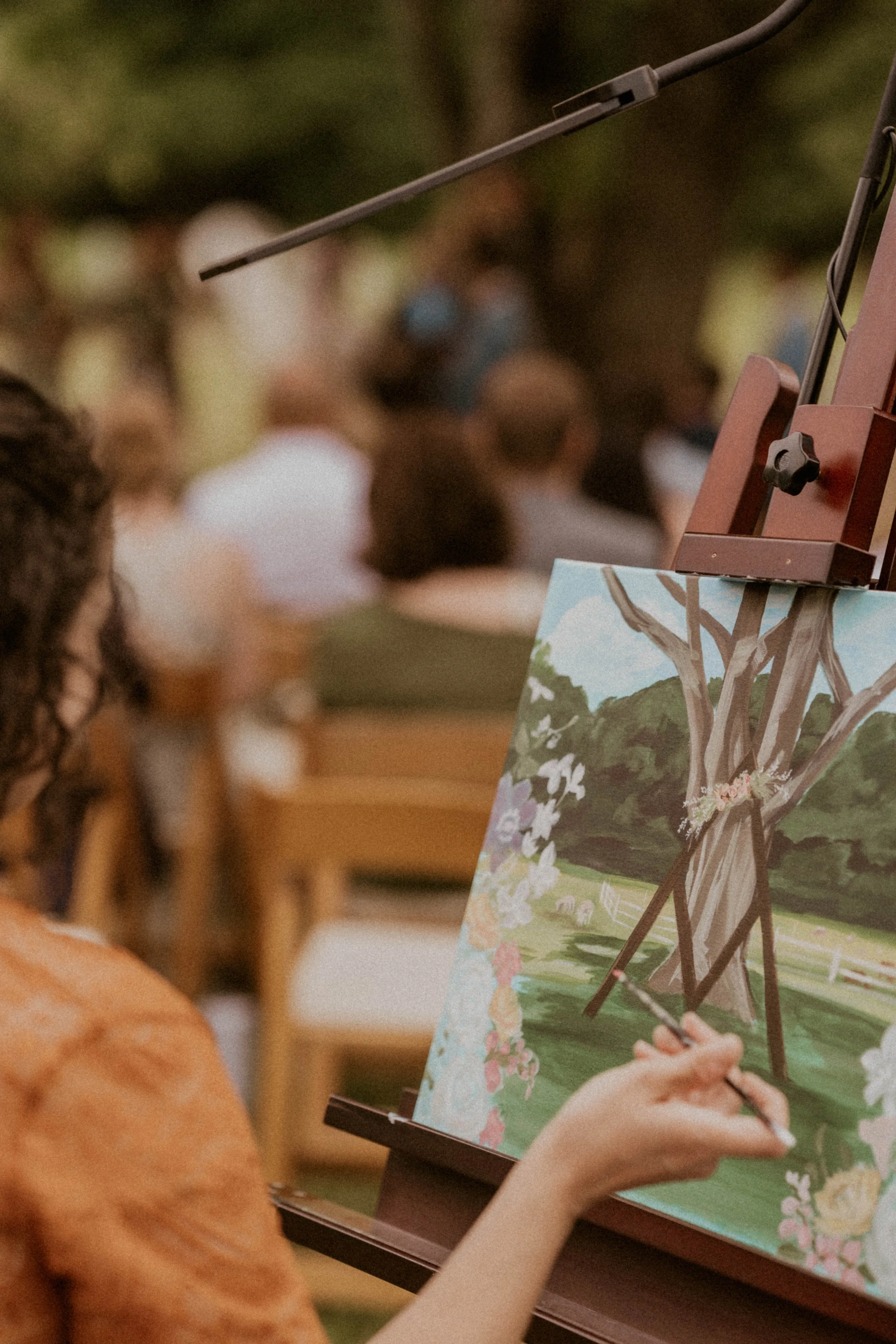 Live painter creating a painting during Madison and Benji's wedding ceremony