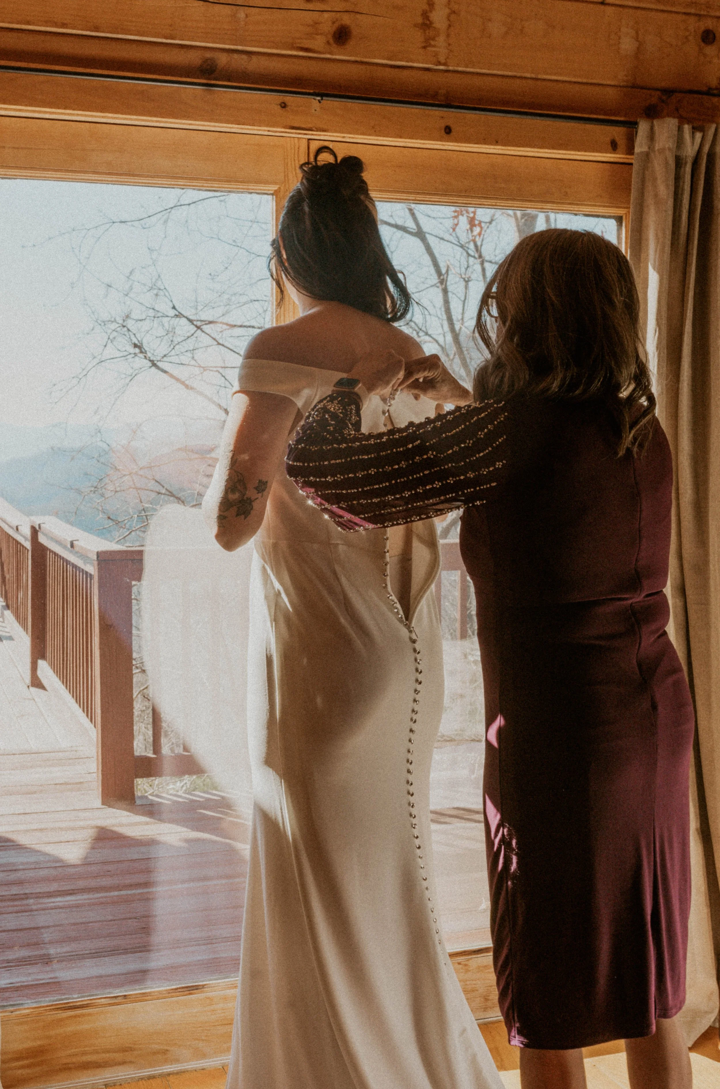 Bride putting on dress during relaxed Asheville elopement morning