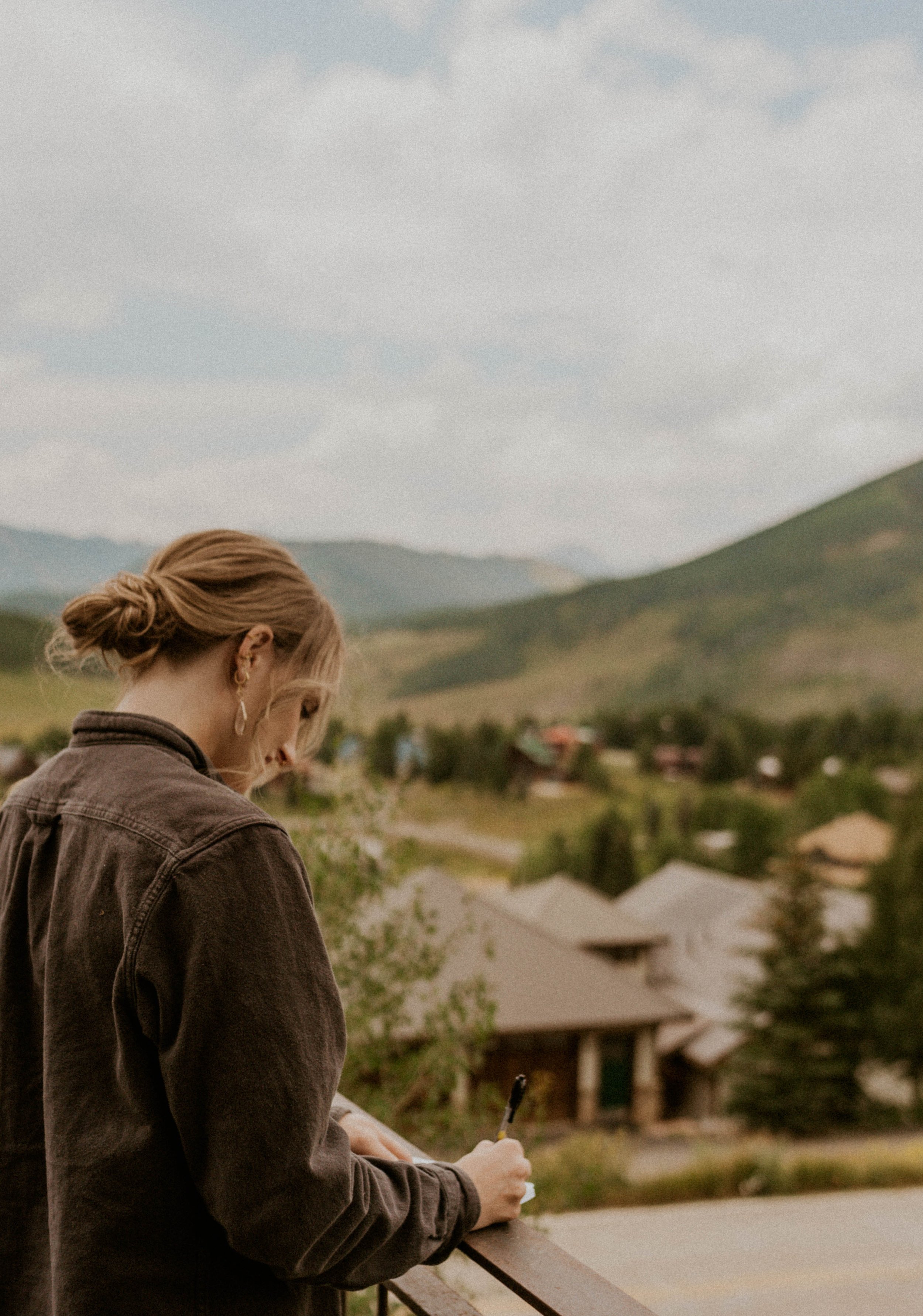 Bride writing wedding vows on the porch of a mountain Airbnb in Crested Butte, Colorado