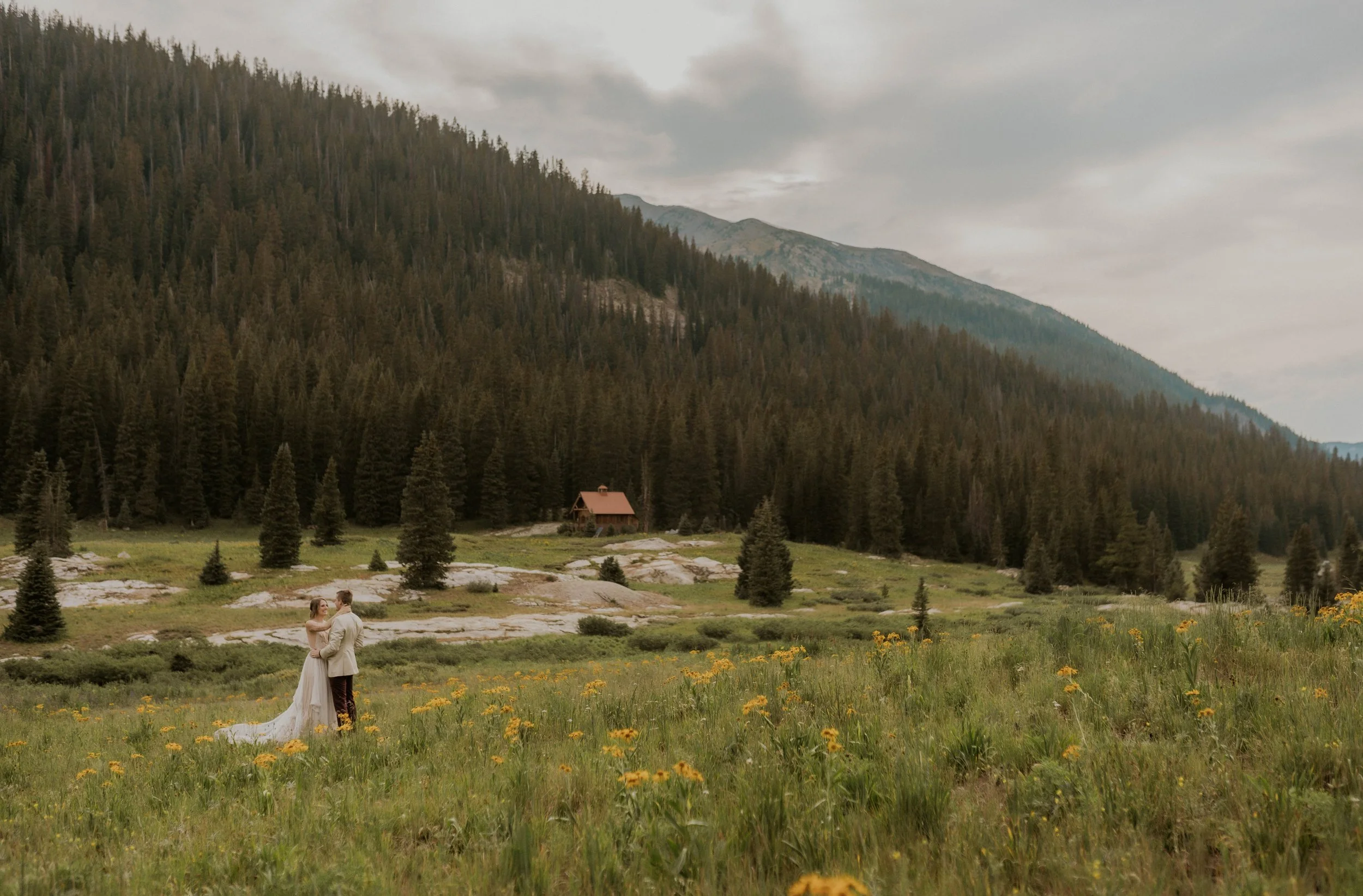 Couple dancing in a wildflower field at golden hour in Colorado