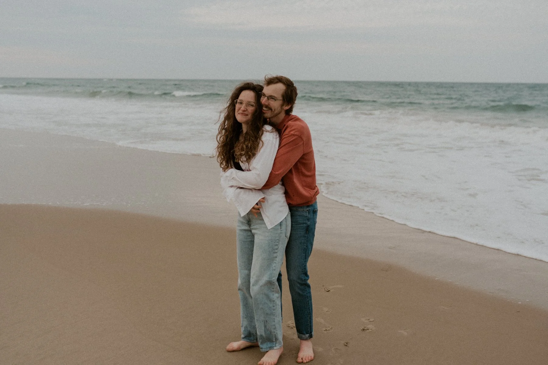 couple standing in misty dunes Outer Banks NC