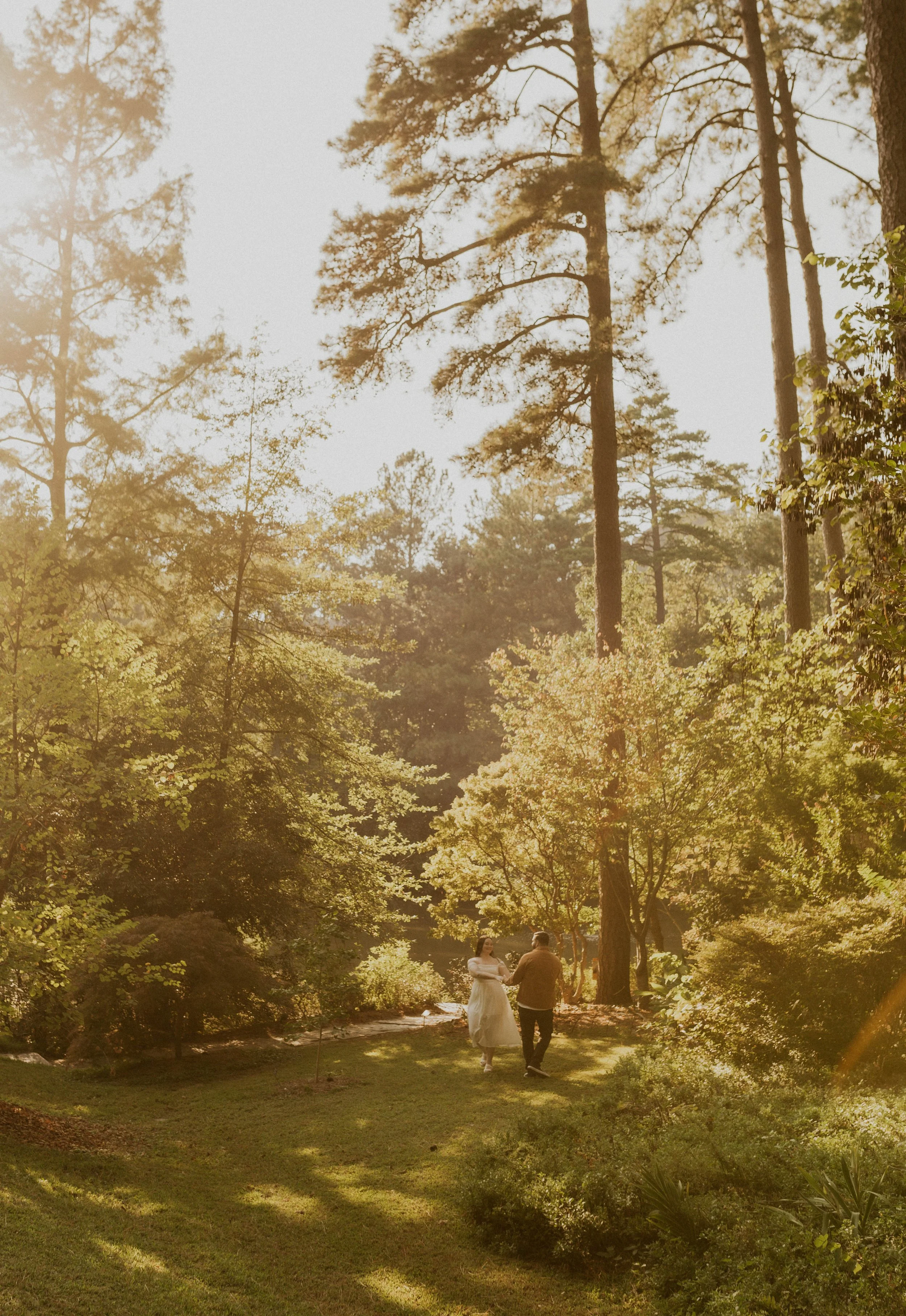 Couple walking through golden hour light during engagement photos at Sarah P. Duke Gardens