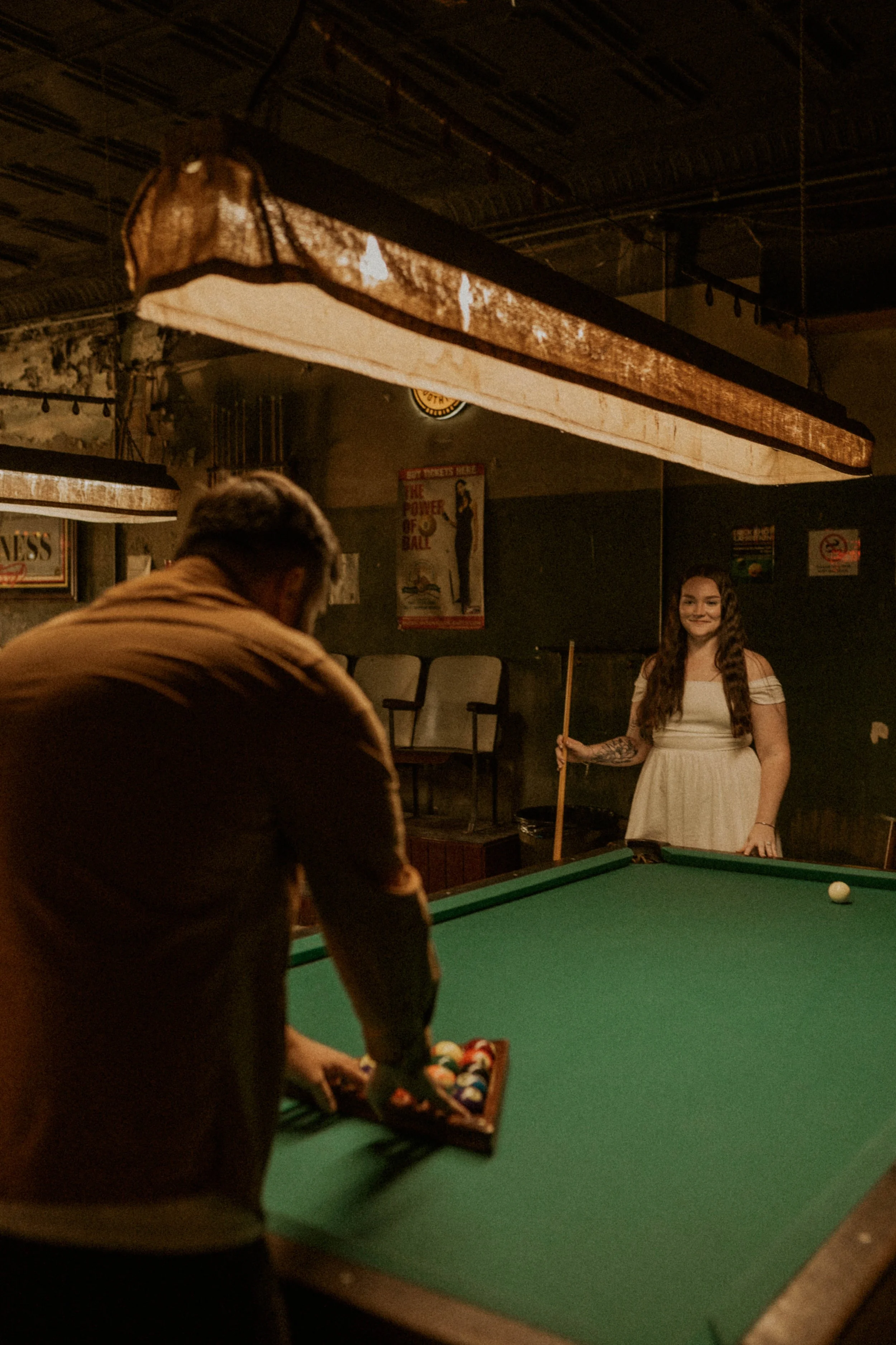 Relaxed engagement session capturing couple playing pool in Durham NC