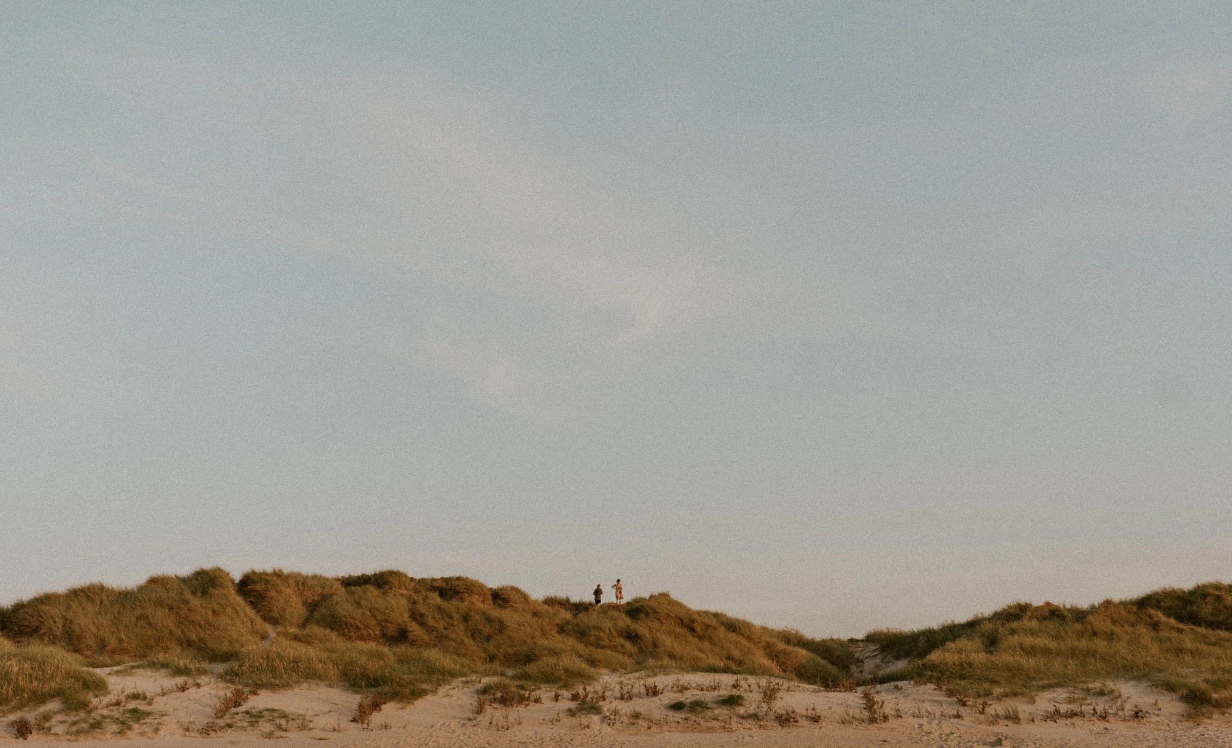 Couple exploring the beach in Denmark before their wedding