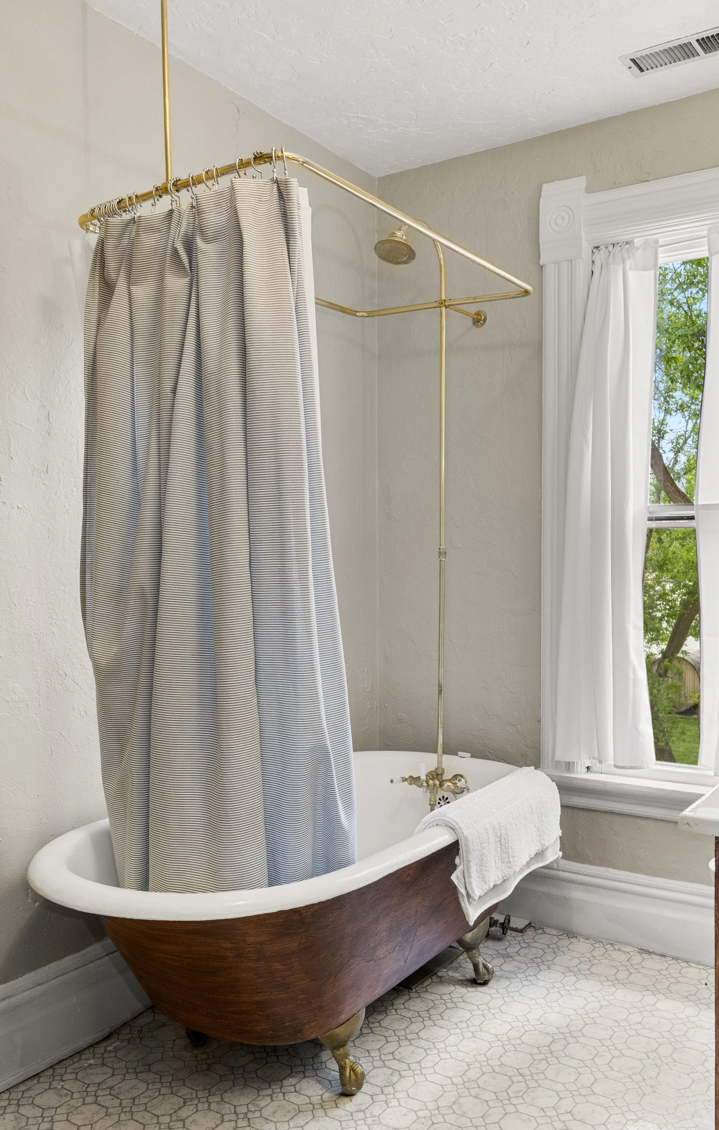 antique clawfoot tub overlooking a view of the garden outside