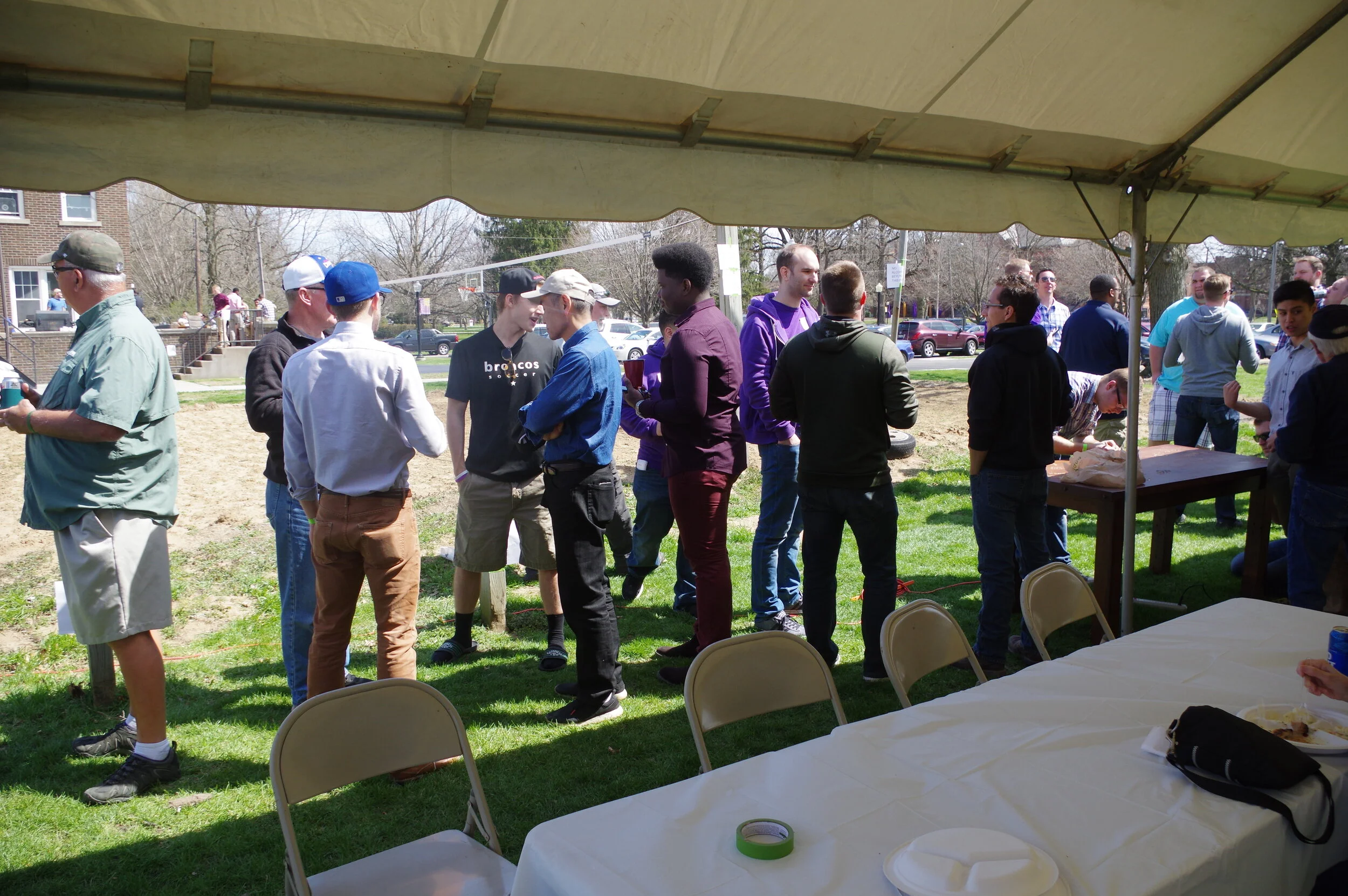 Brothers join in conversation while table carving continues, far right.JPG