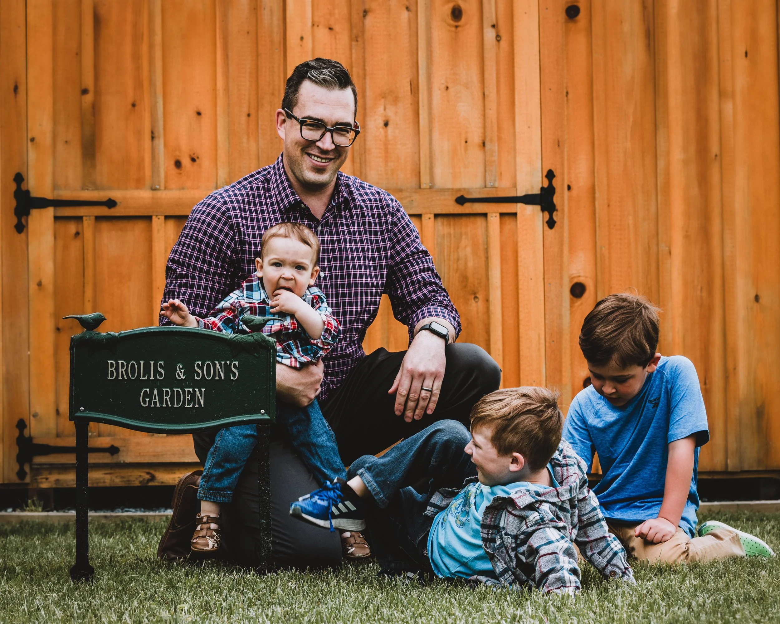 Father and children playing on grass during outdoor family photo session in South Jersey