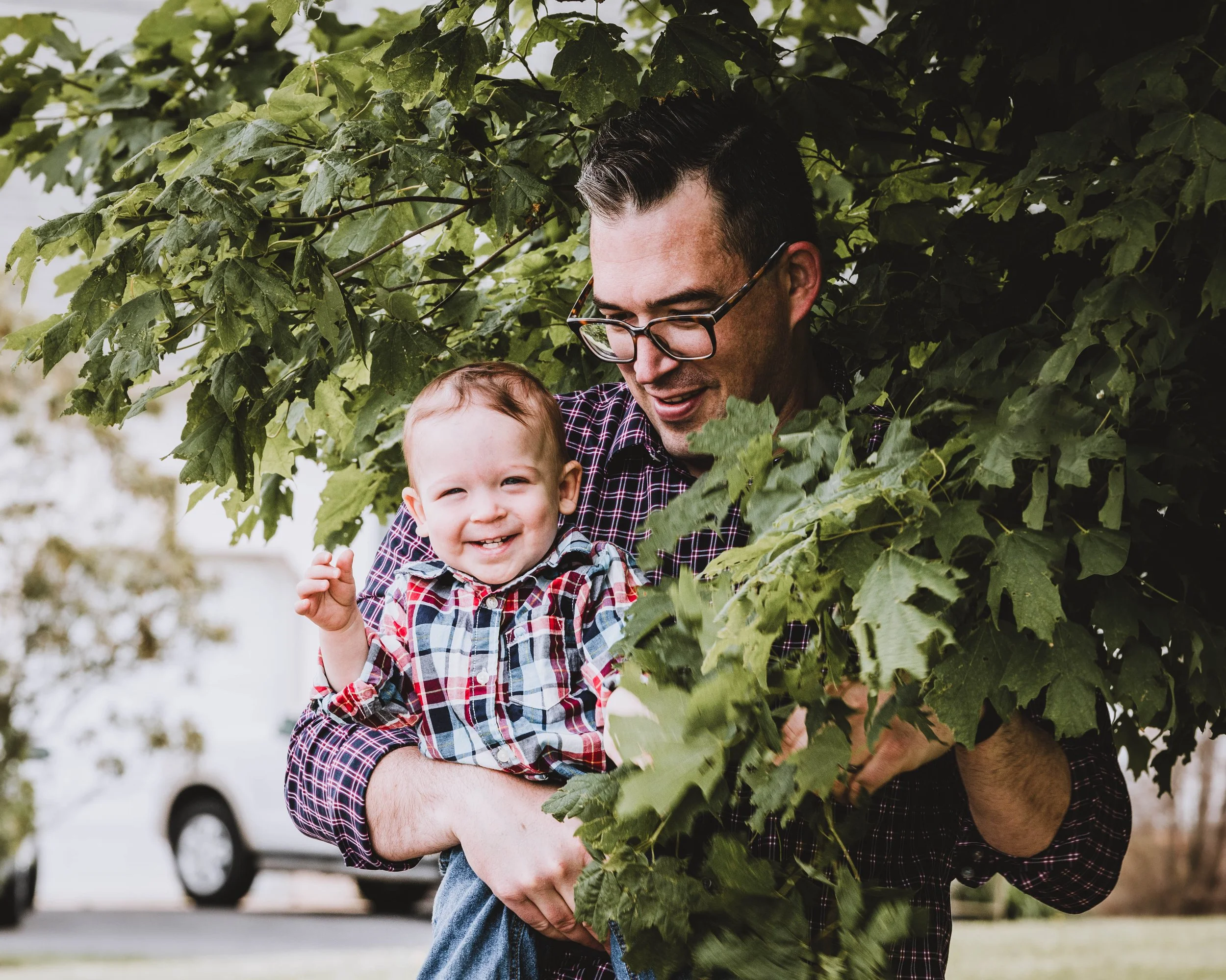 Father holding young child outdoors during family photography session in South Jersey