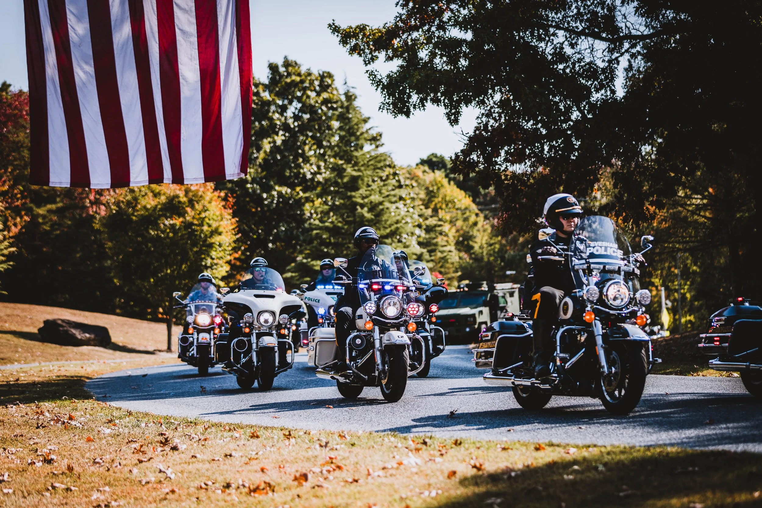 Bikers passing an American flag tribute during a memorial ride in New Jersey.