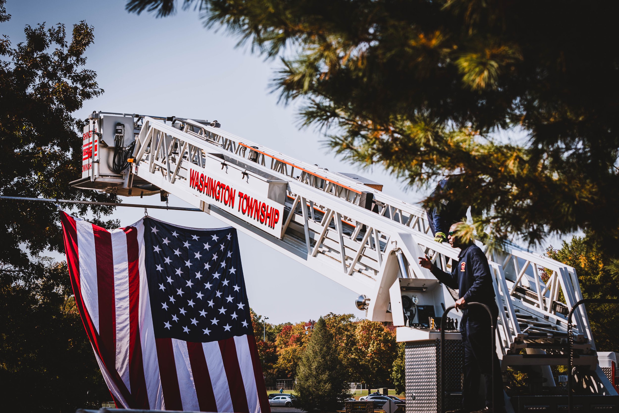 Fire truck ladder and American flag display for a Gloucester County community memorial event.