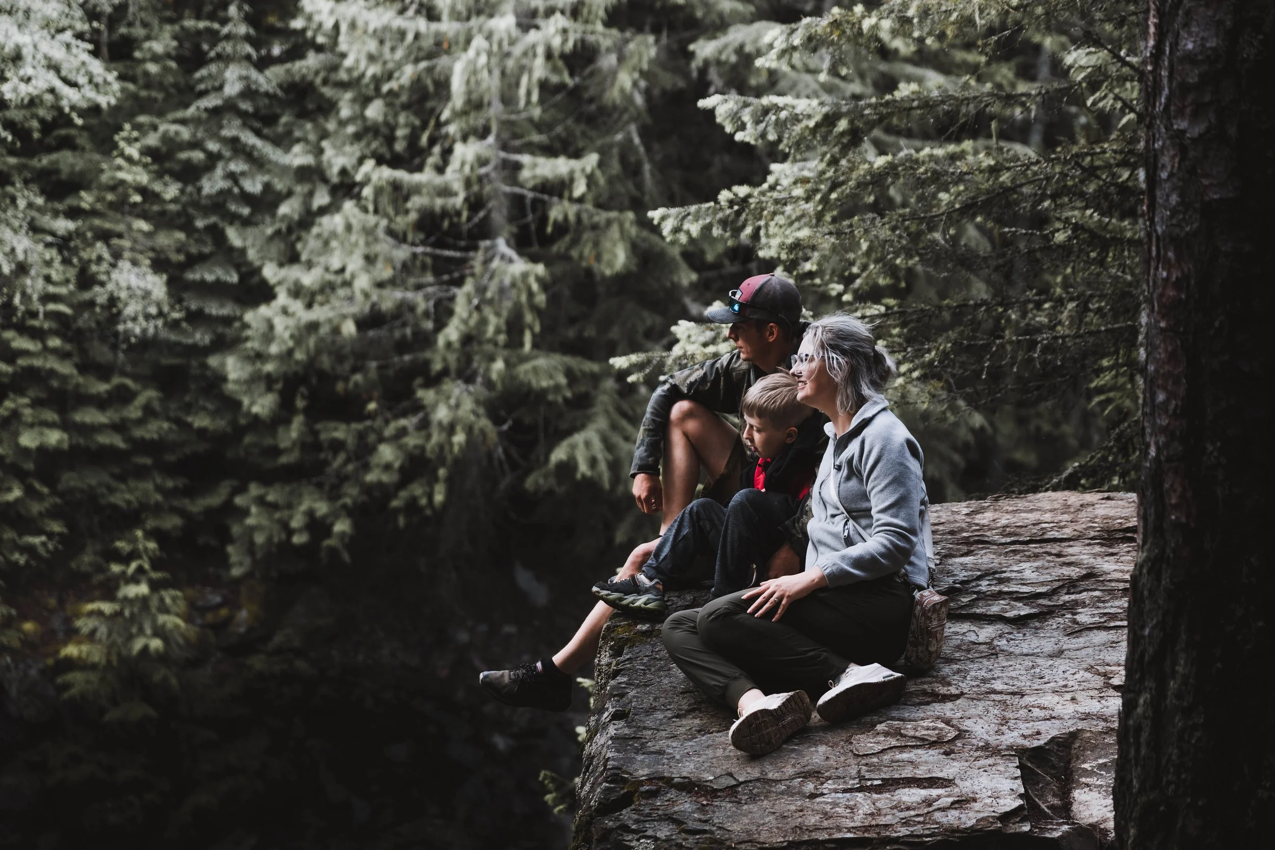 Couples portrait session in a forest location, featuring a candid, relaxed moment surrounded by nature.