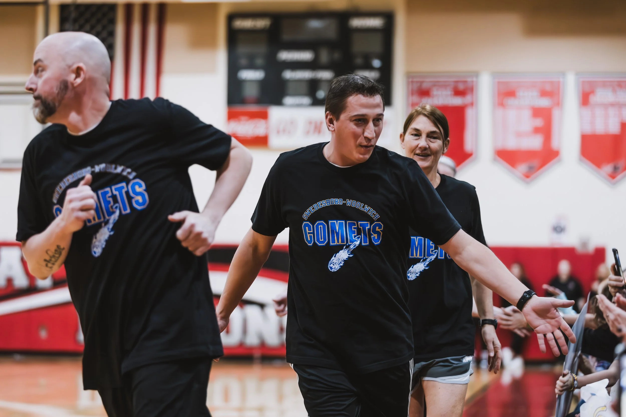 Three individuals wearing black T-shirts with the word 