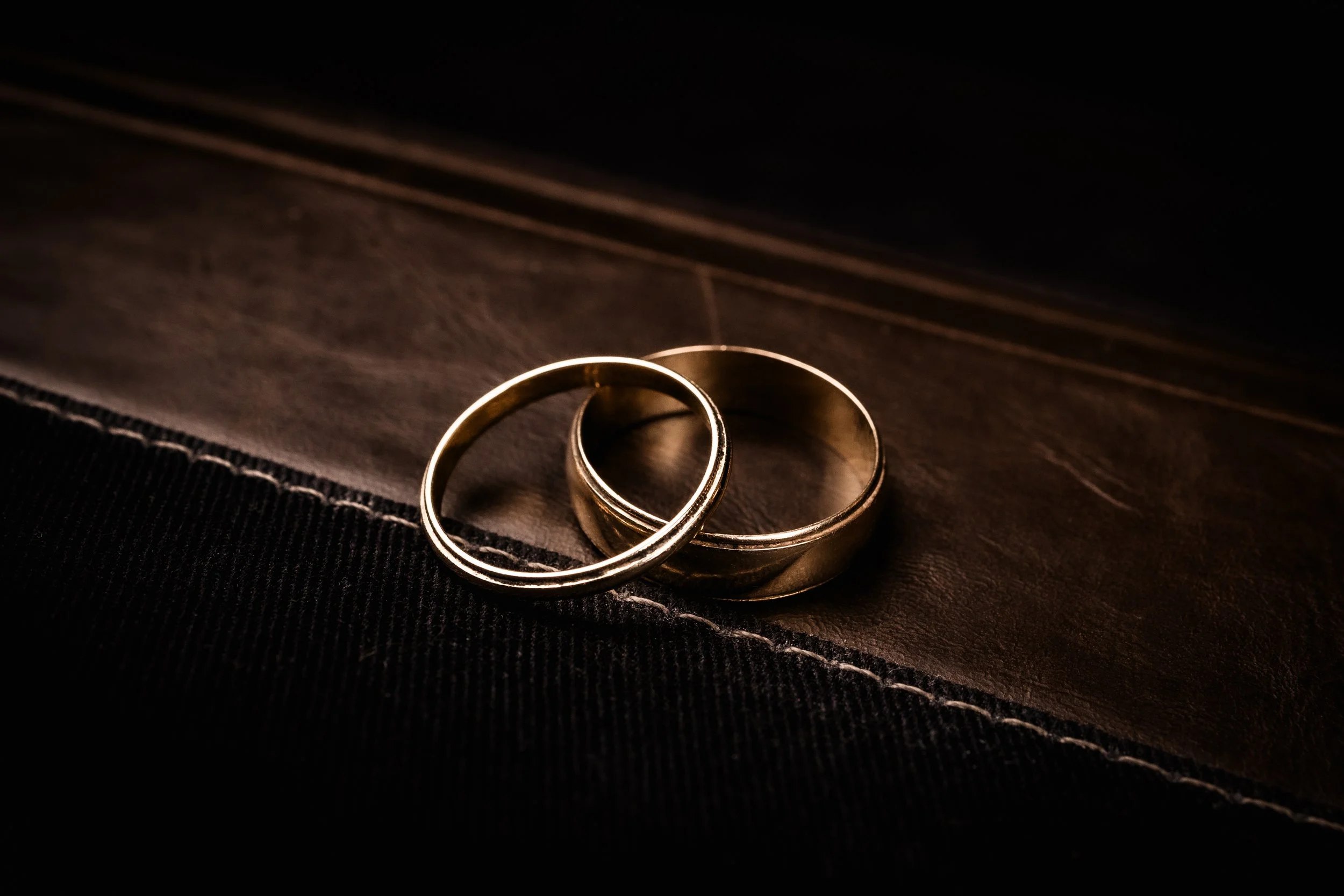 Wedding detail photography in South Jersey, featuring a close-up of wedding rings captured with artistic lighting.