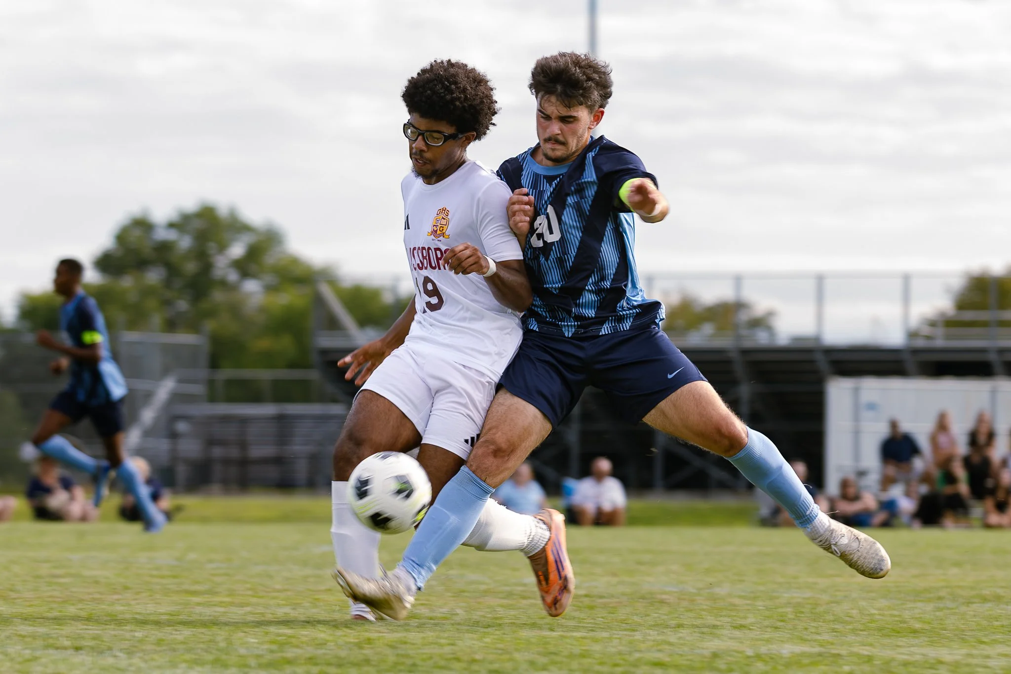 Players from Highland Regional and Glassboro battle for possession in an intense moment from their varsity soccer scrimmage.