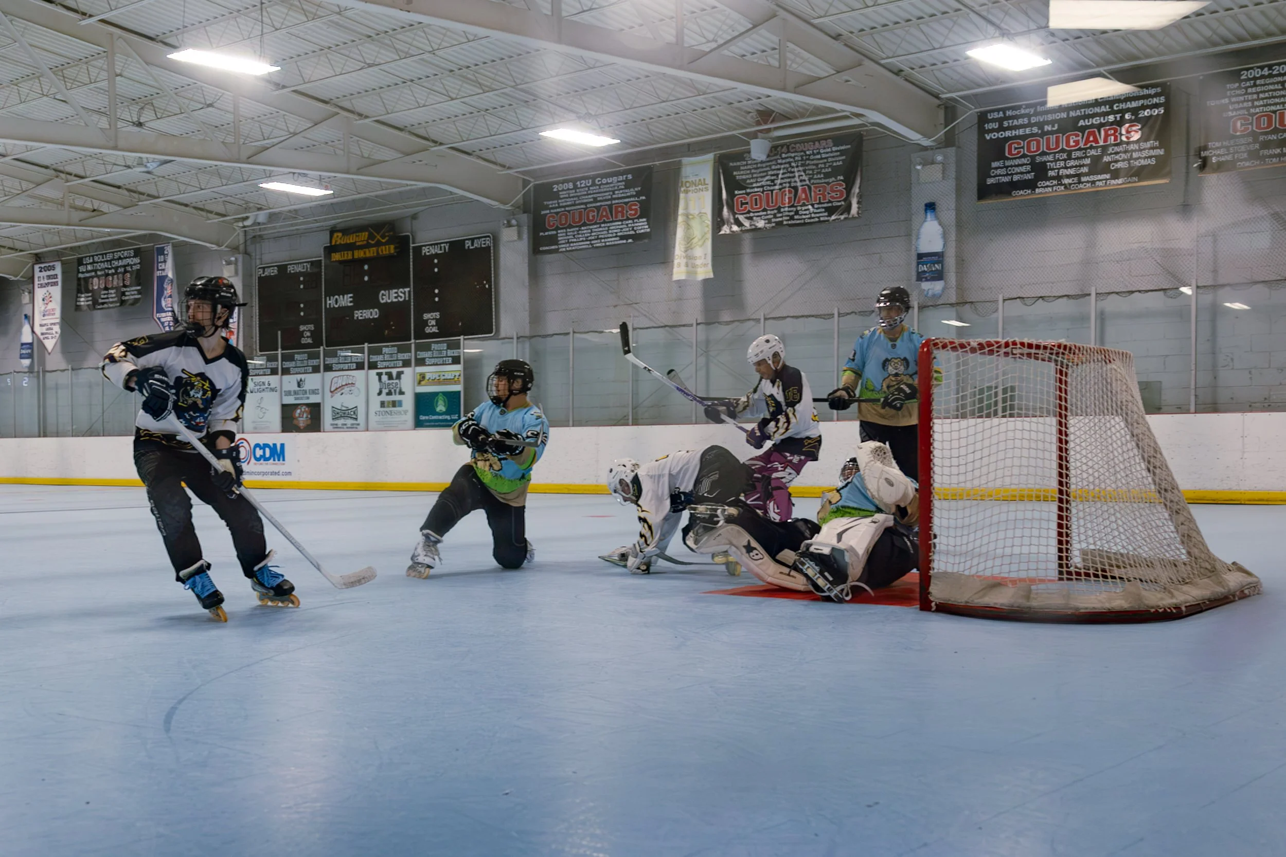 Roller hockey goalie making a save as players battle in front of the net at Choice Inline Arena in Pitman, New Jersey.