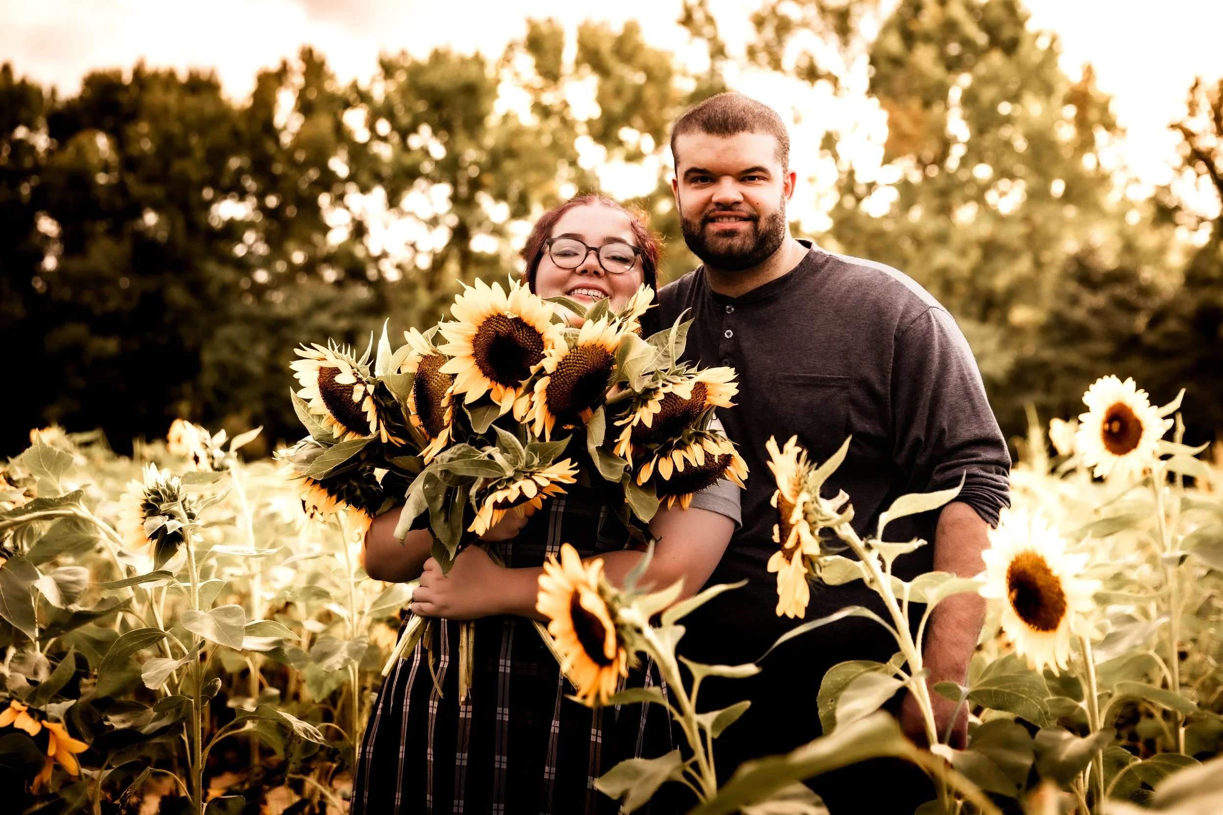 Romantic couple's portraits surrounded by golden sunflower fields at Dalton Farms.