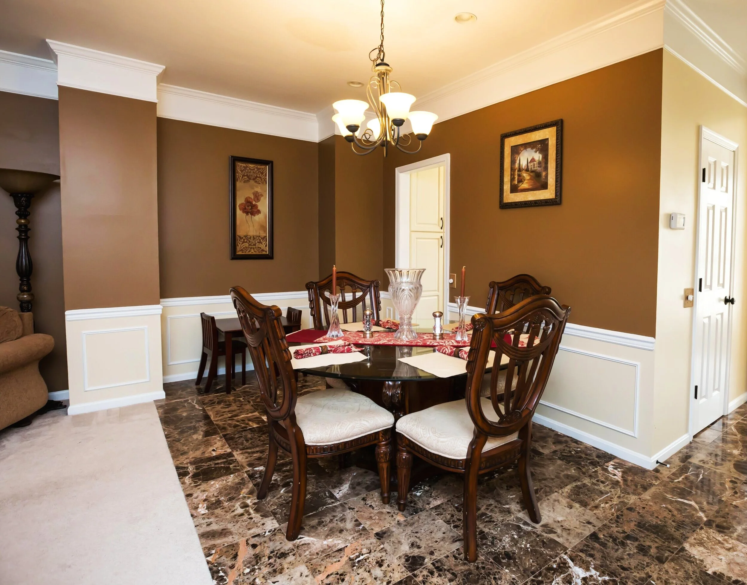 A table set for royalty! Comfortable and elegant engraved wood chairs, a table for the children, and an immaculate tiling transition from lounge room to dining area.