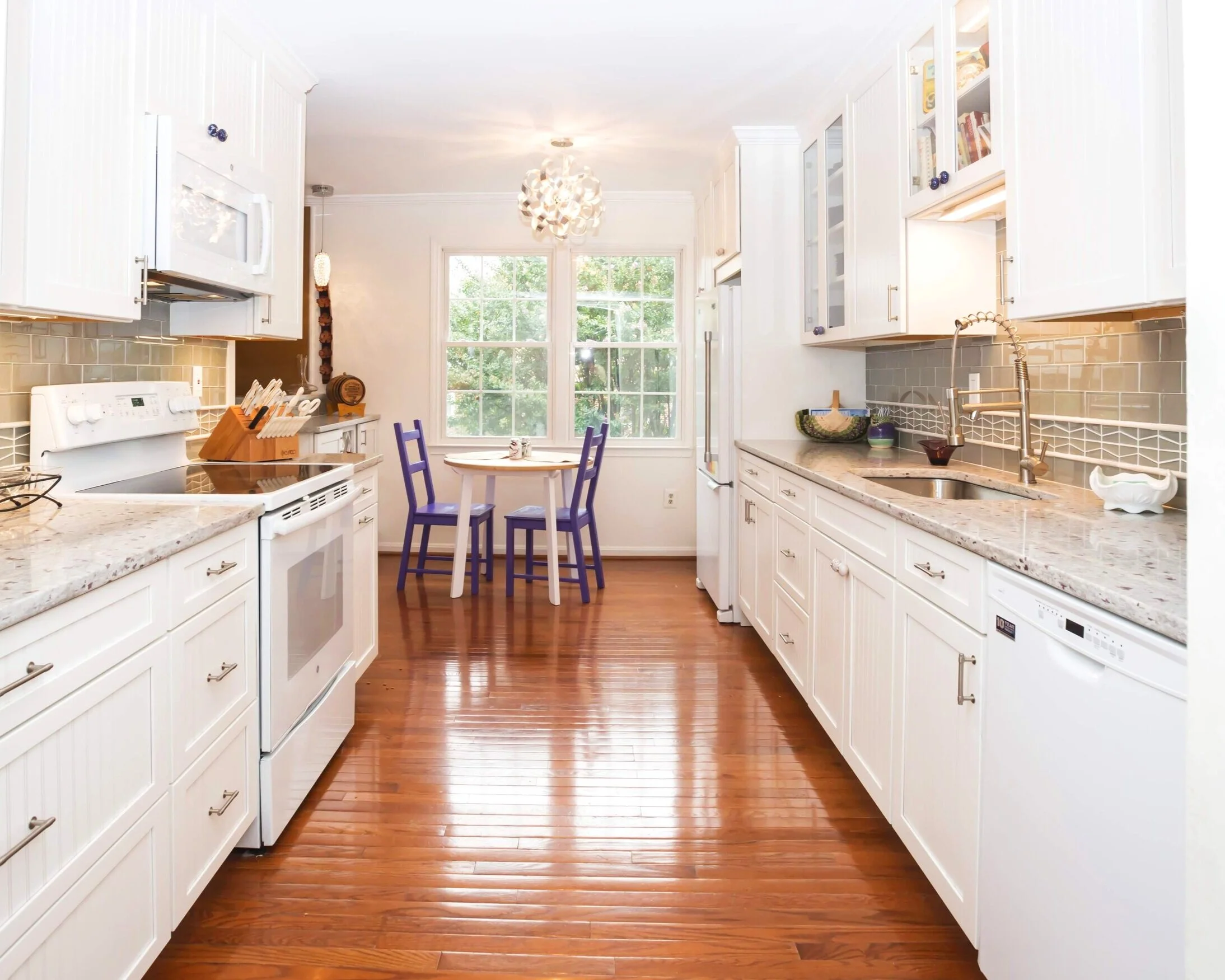 This playful, well lit kitchen is perfect for family dinners and prepping your favorite recipes for company during the holidays. Complete with handmade cream cabinets, seats for the little ones, and wonderful wood floors - you’ll want nothing more t…