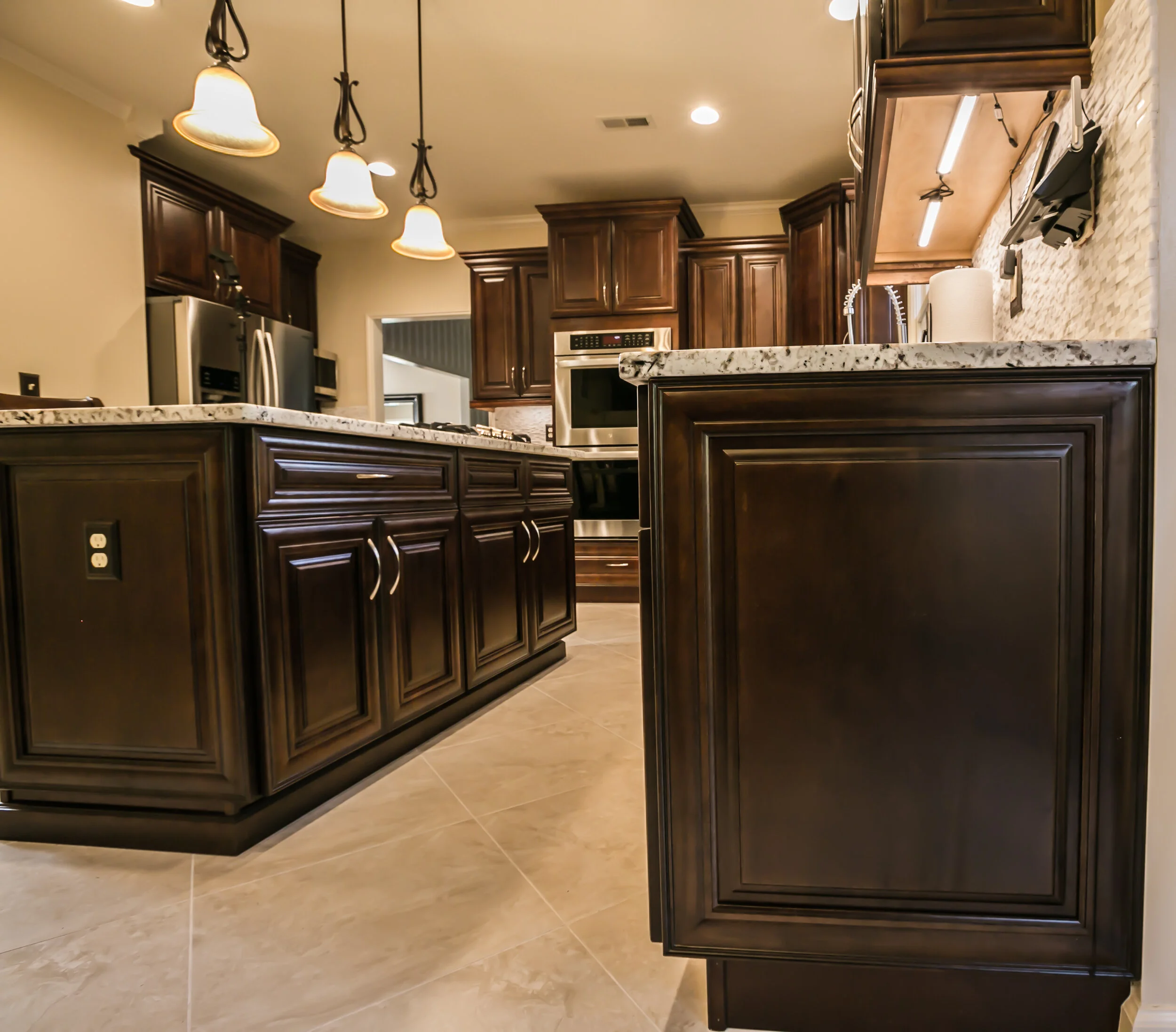 A view of the gorgeous custom cabinetry on this kitchen remodel - carefully chosen to match the lighting and flooring.