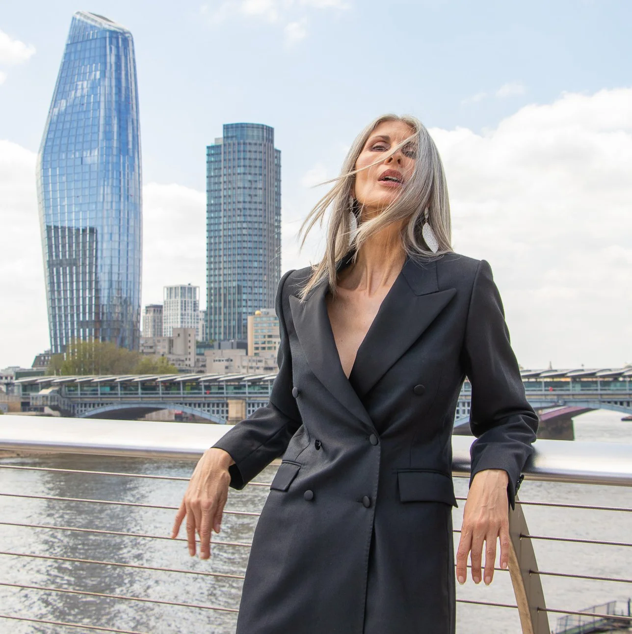 Banshee of Savile Row bespoke women's tailoring showing a black double breasted jacket dress with lapel collar and four buttons.