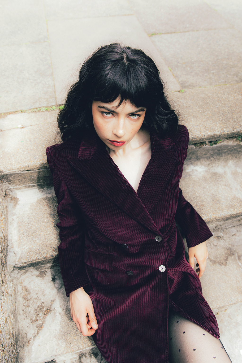 Banshee of Savile Row bespoke women's tailoring showing a plum corduroy double breasted jacket dress with lapel collar and four buttons.