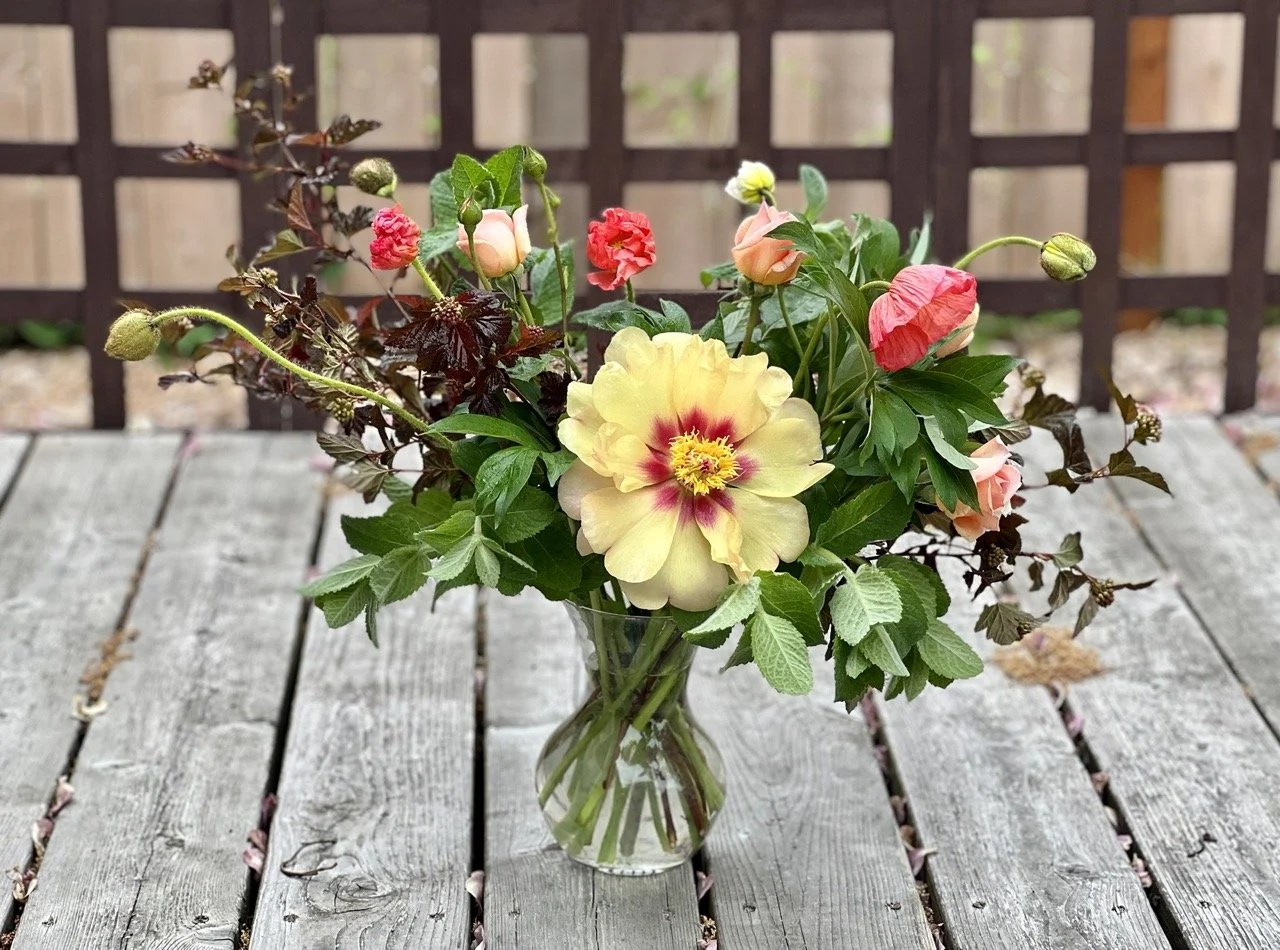 Spring arrangement of yellow peony, mint and icelandic poppies