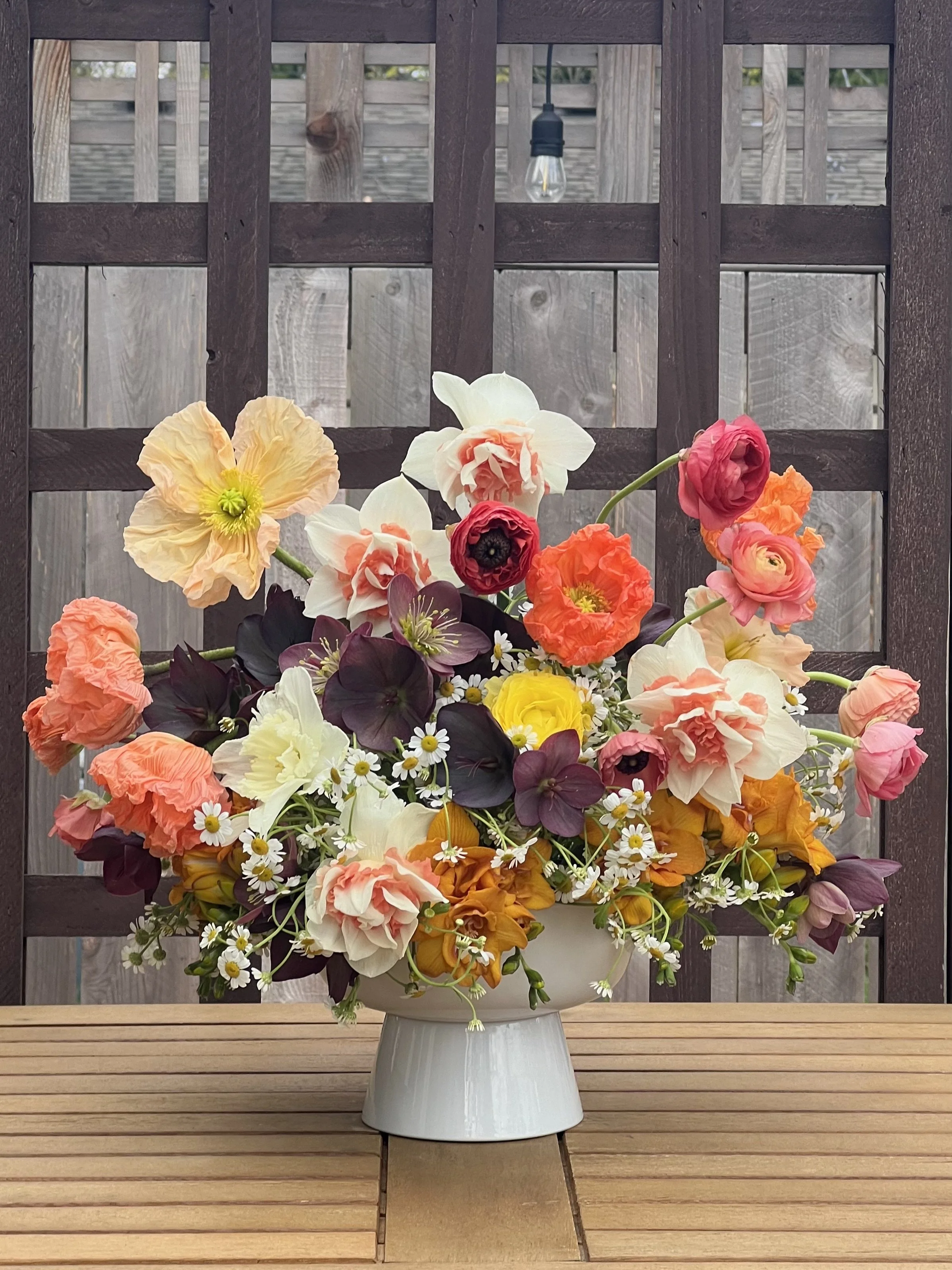 Compote of poppies, daffodils, ranunculus, hellebore, and freesia
