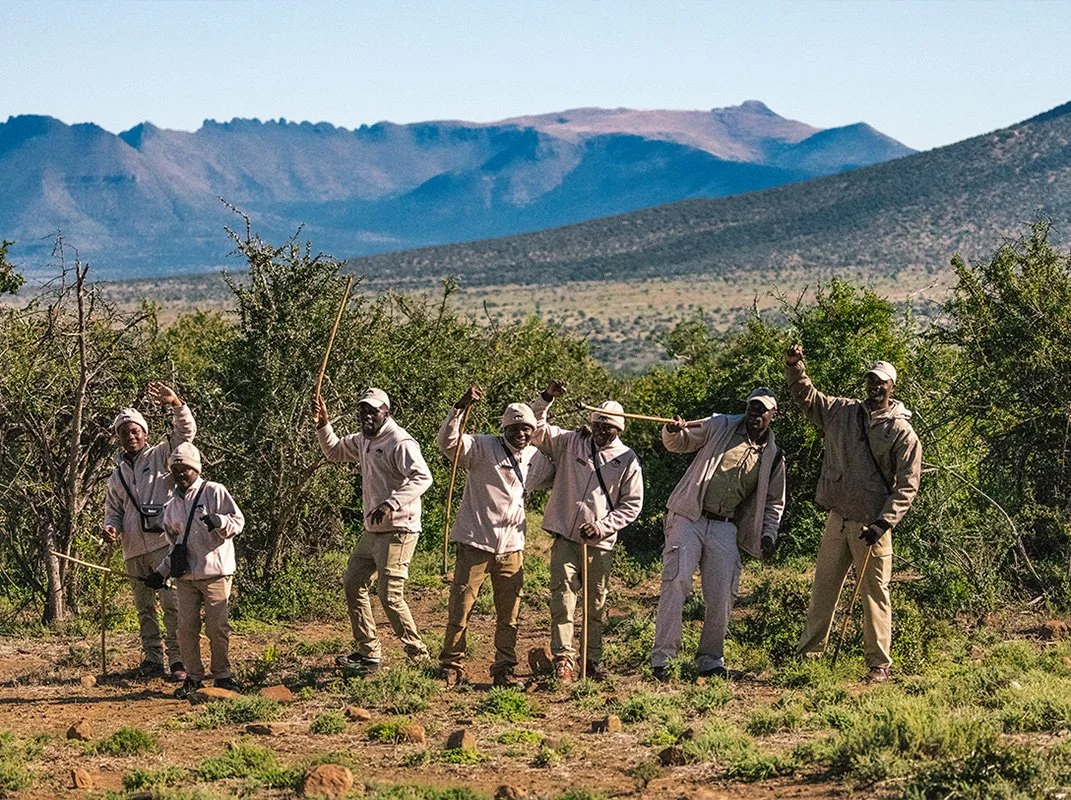 men pose in a line, outdoors