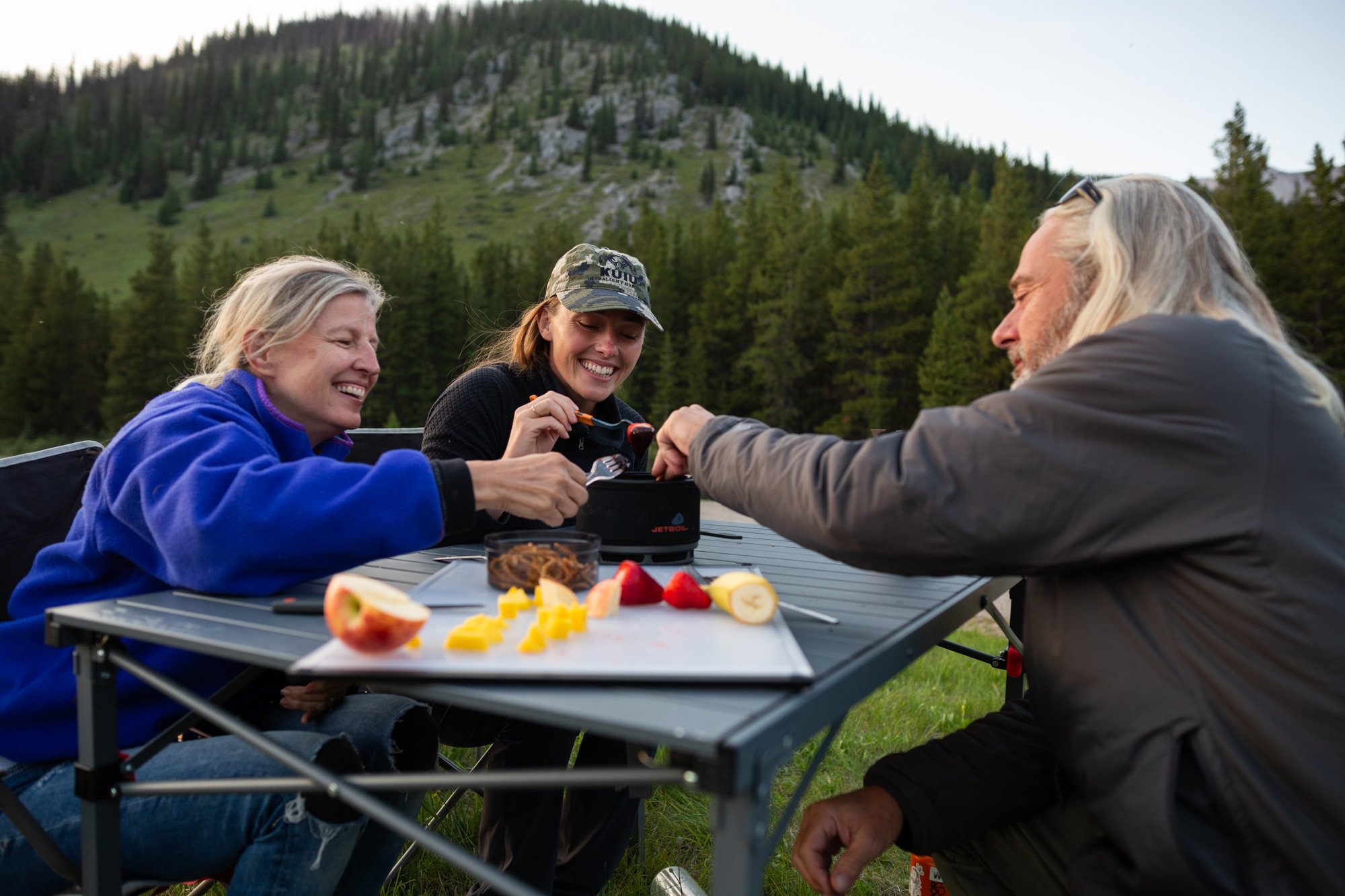 FAMILY EATING DINNER TOGETHER WHILE CAMPING