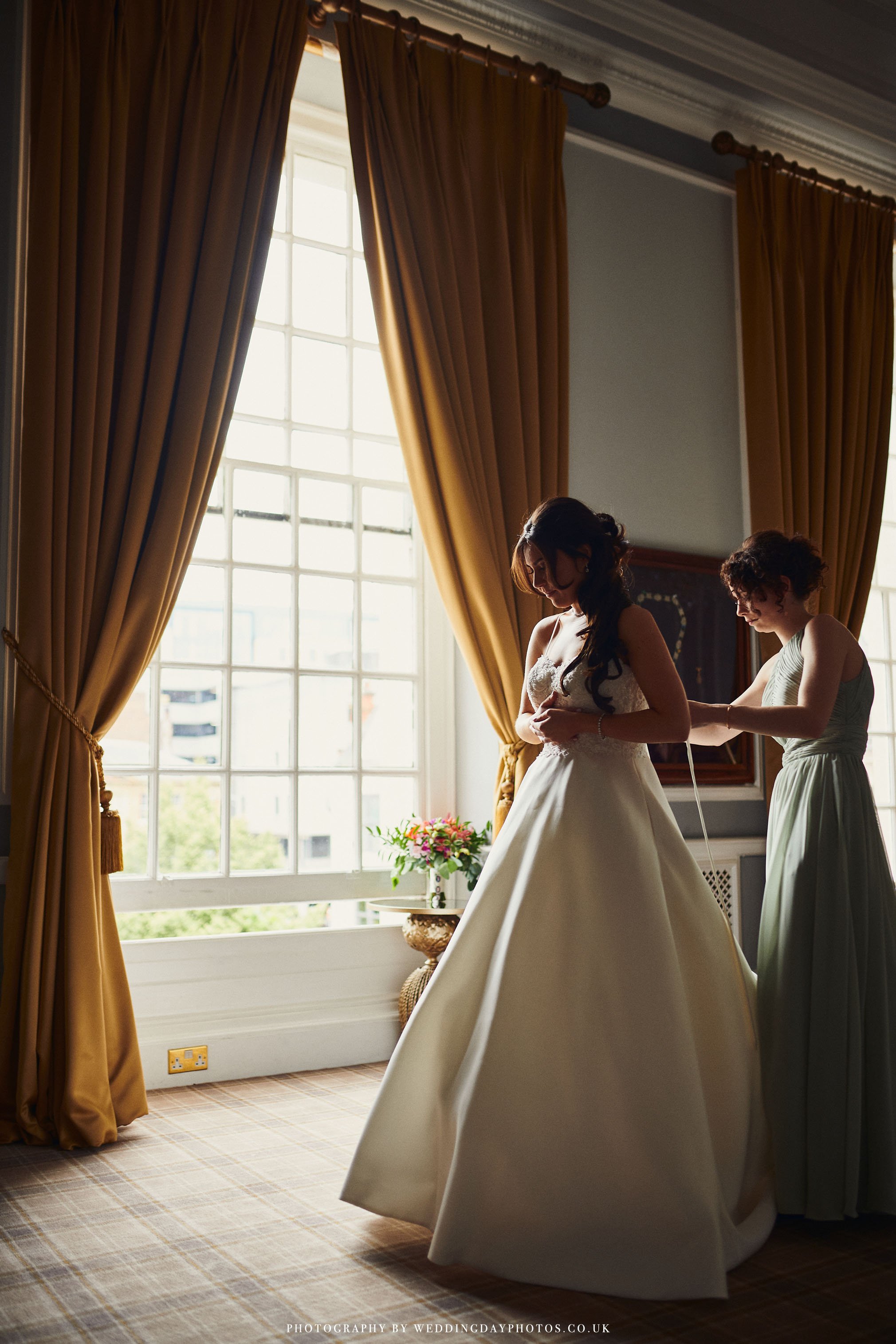 beautiful images of the bride dressing in natural window light at manchester hall wedding