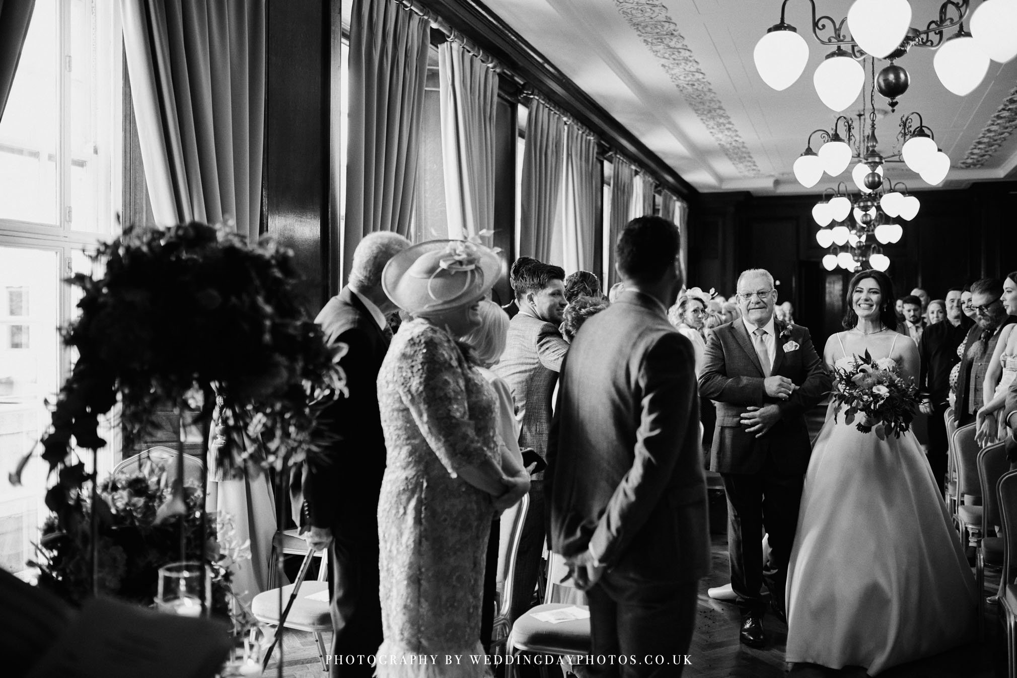 bride and father walking down the aisle during a wedding at manchester hall in the gallery