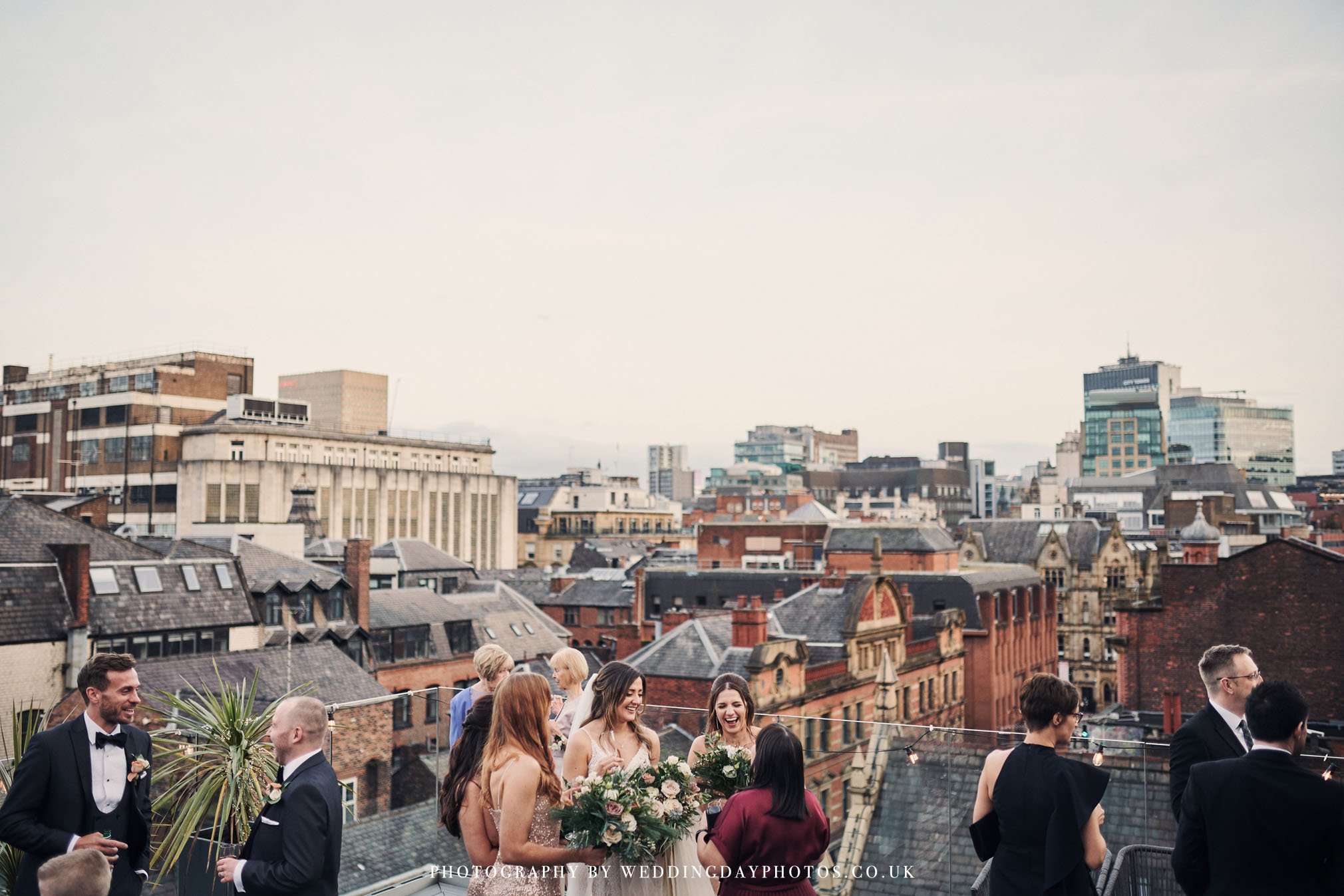 wedding guests enjoying the outdoor space on manchester hall's John Rylands rooftop terrace