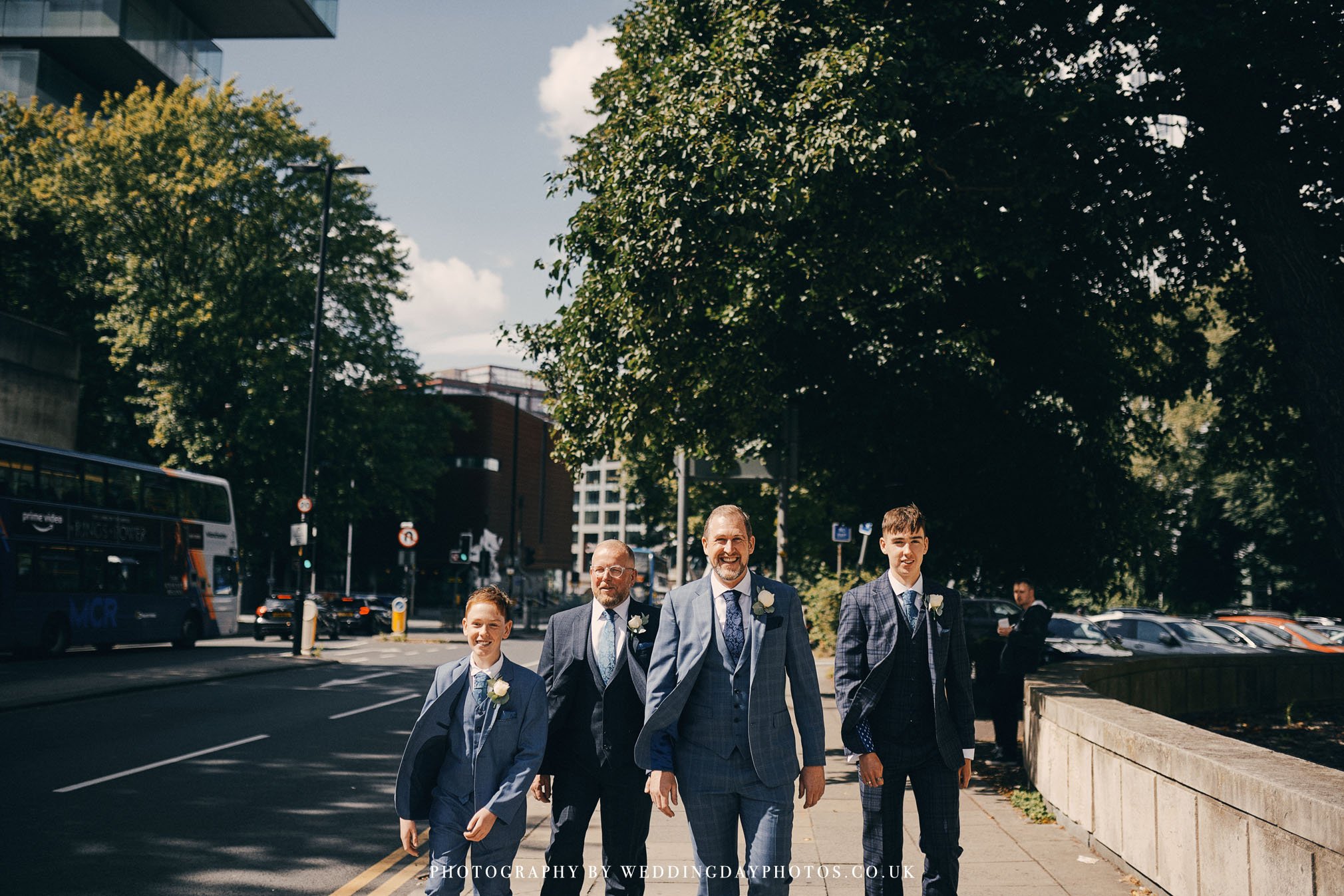 groom and groomsmen looking smart whilst walking towards manchester hall for a wedding ceremony
