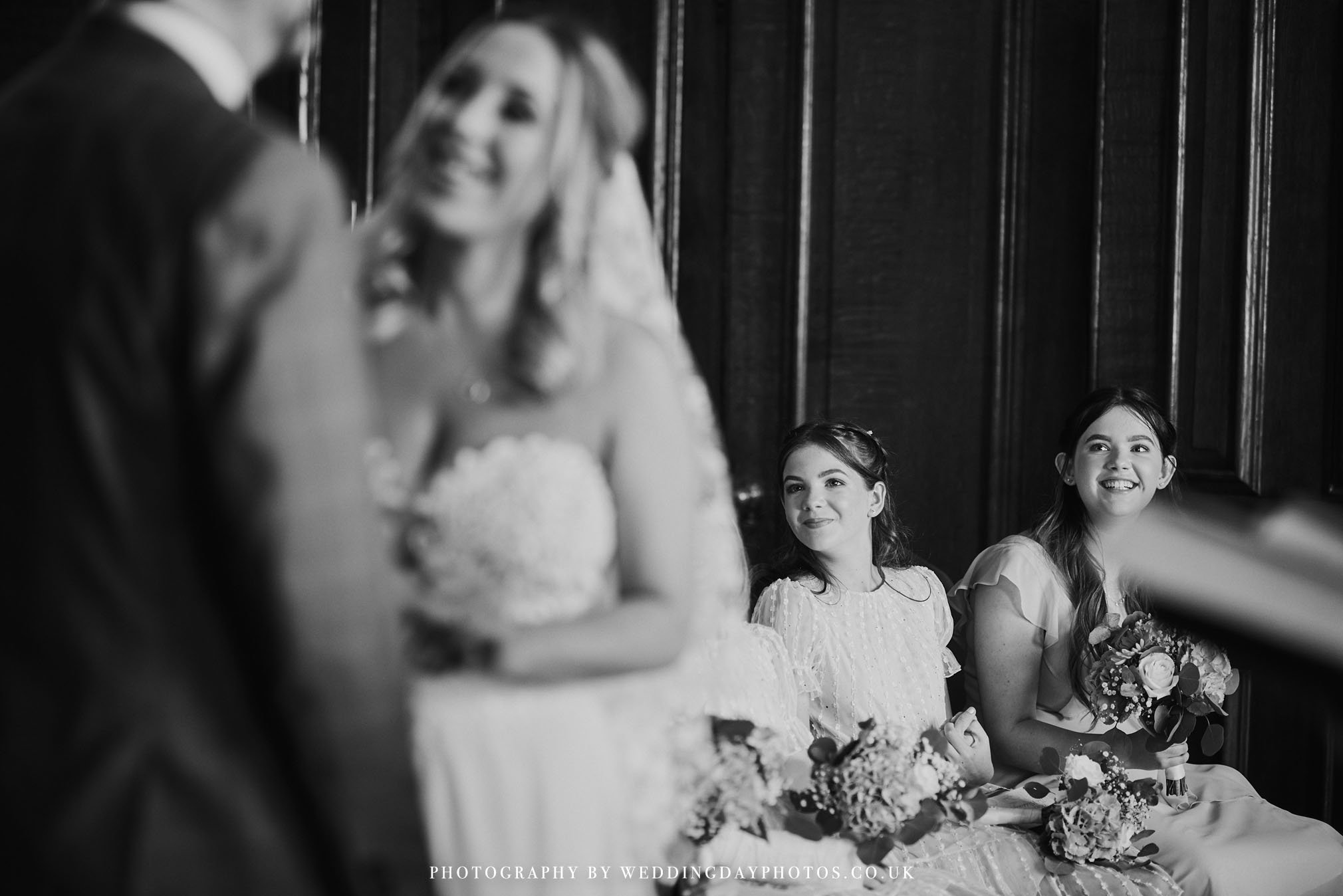 adorable photo of bridesmaids watching wedding ceremony at manchester hall in the drawing room